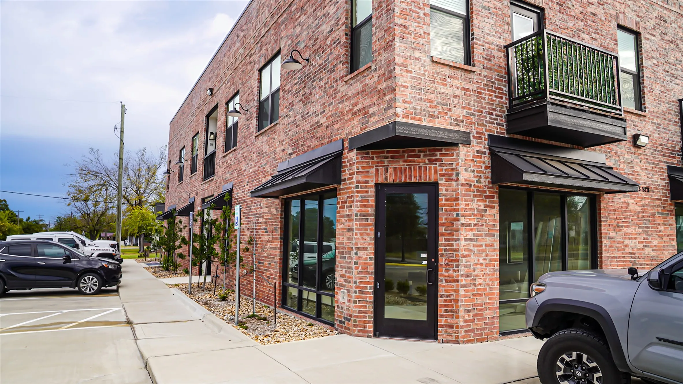Front of the building, neighboring commercial doorway and public parking lots for entire building
