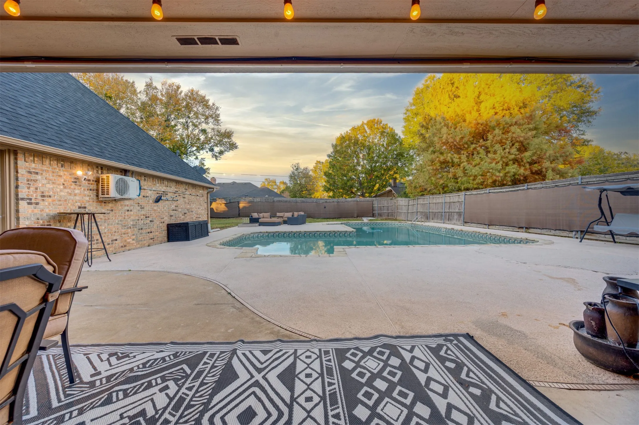 Pool at dusk featuring a fenced backyard and large patio