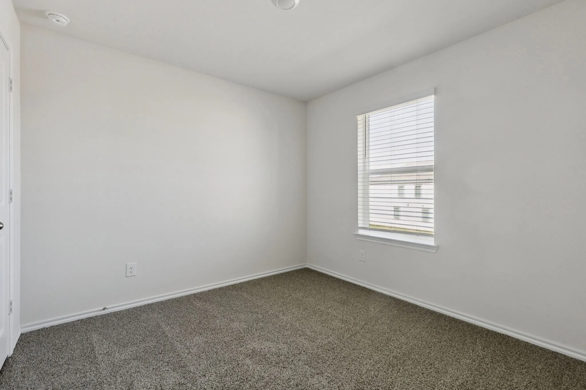 Carpeted empty room with baseboards