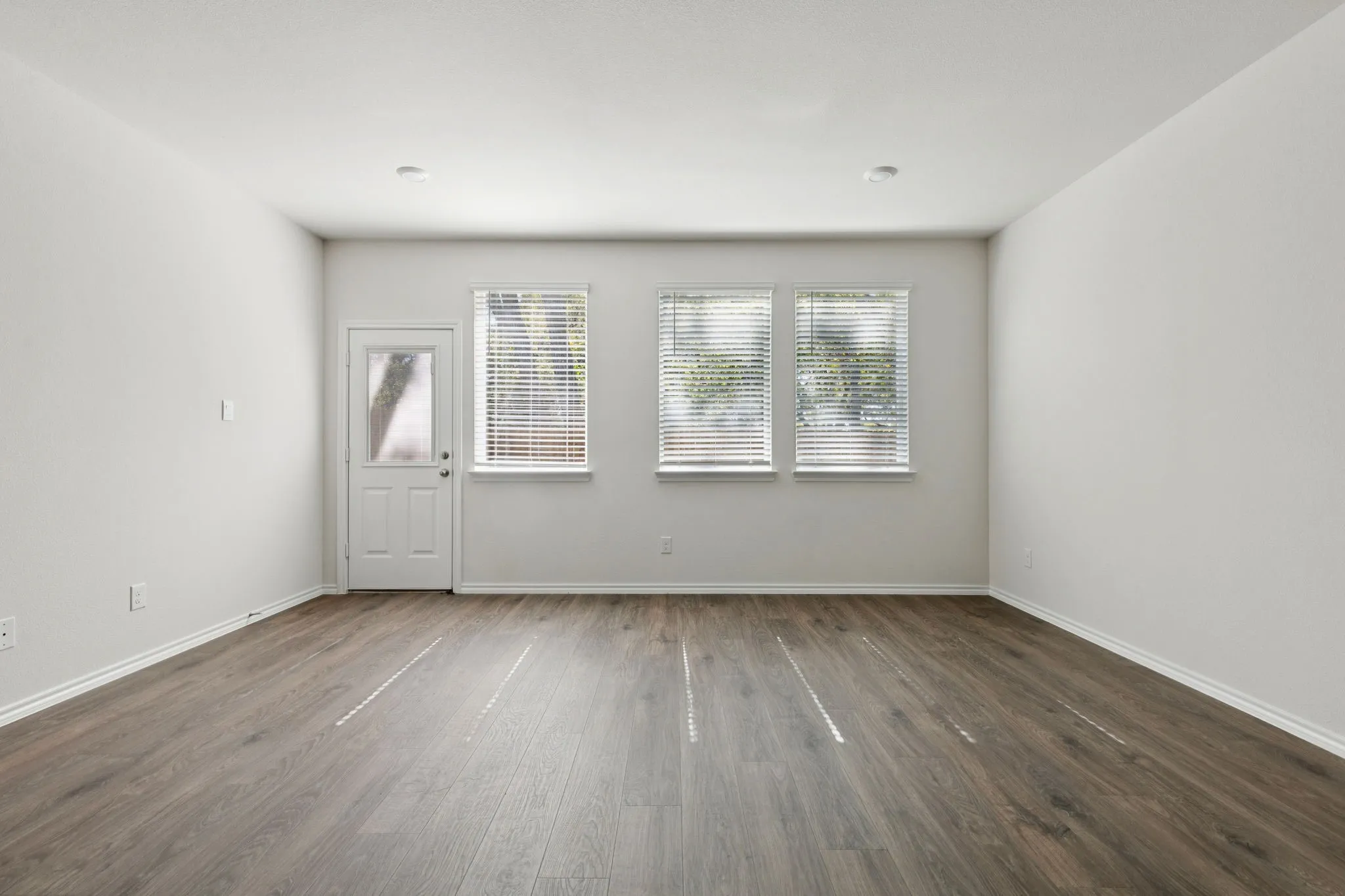 Unfurnished room featuring plenty of natural light and dark wood-type flooring