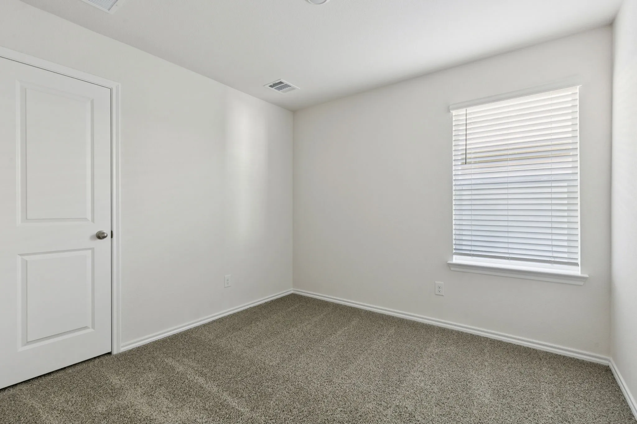 Carpeted empty room featuring baseboards