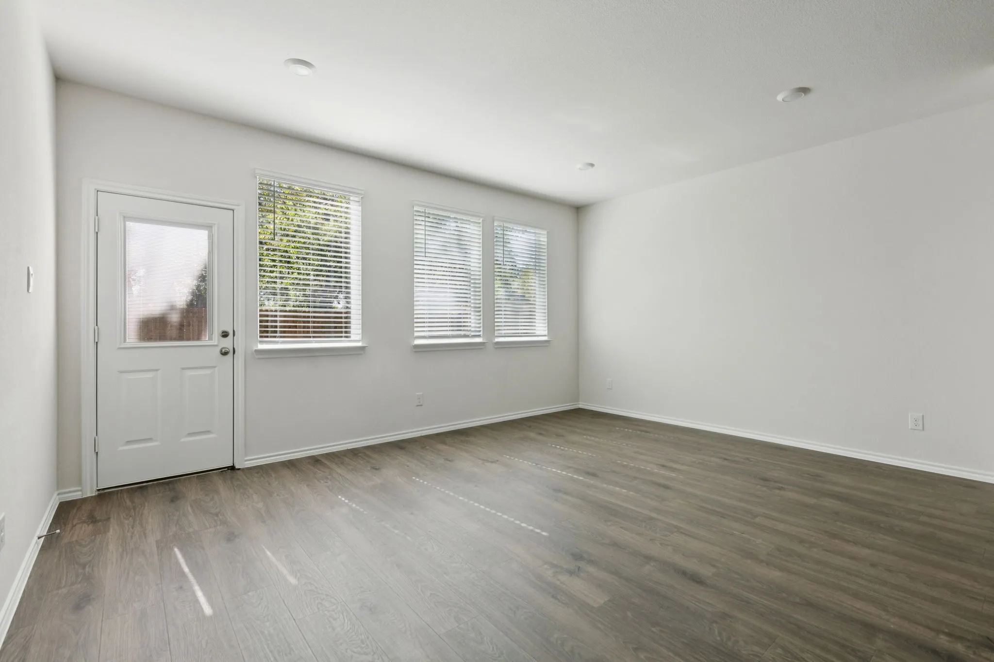 Empty room with dark wood finished floors and baseboards