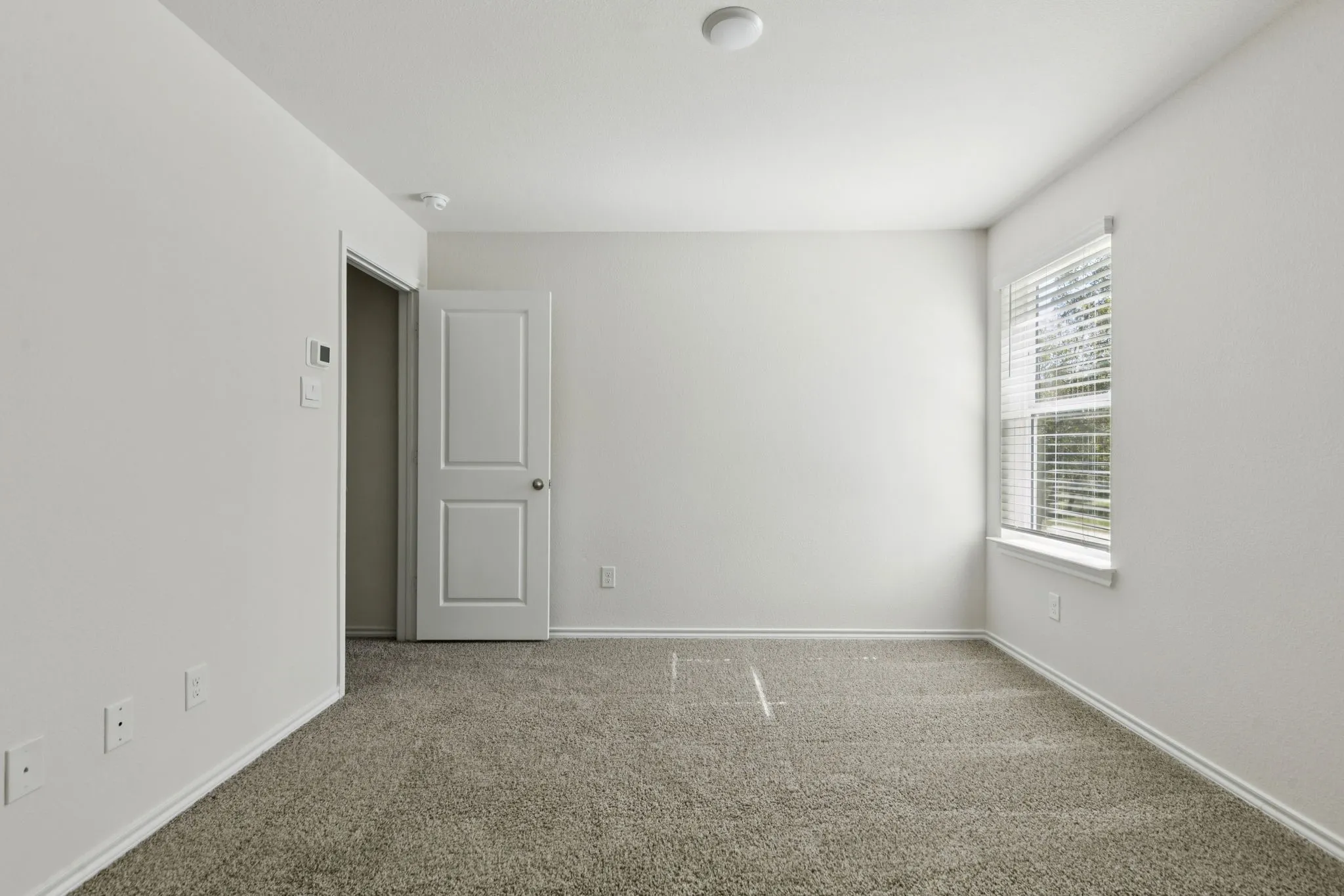 Carpeted empty room featuring baseboards