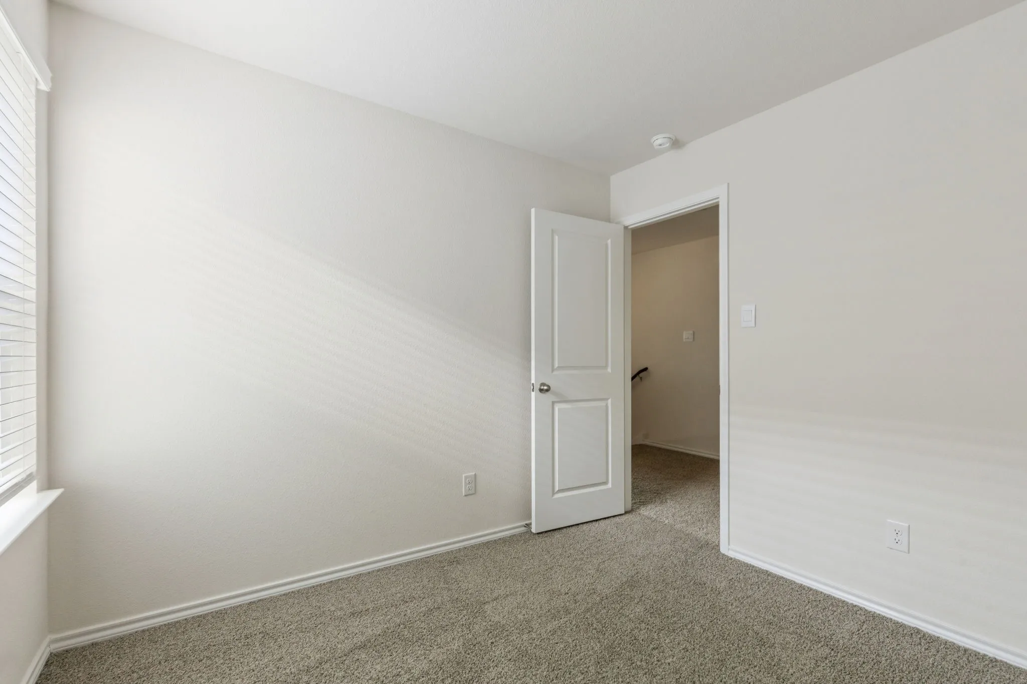 Empty room with carpet flooring and healthy amount of natural light
