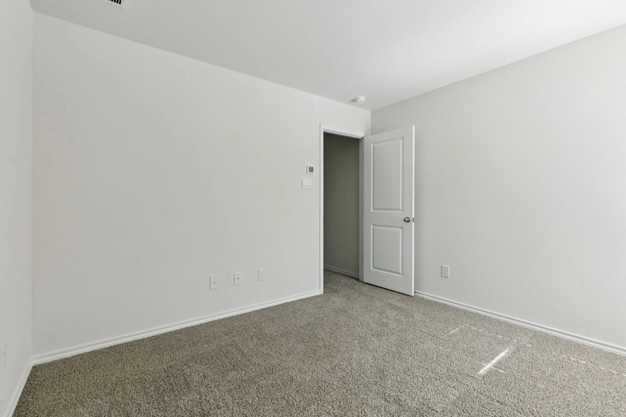 Empty room with carpet flooring and baseboards