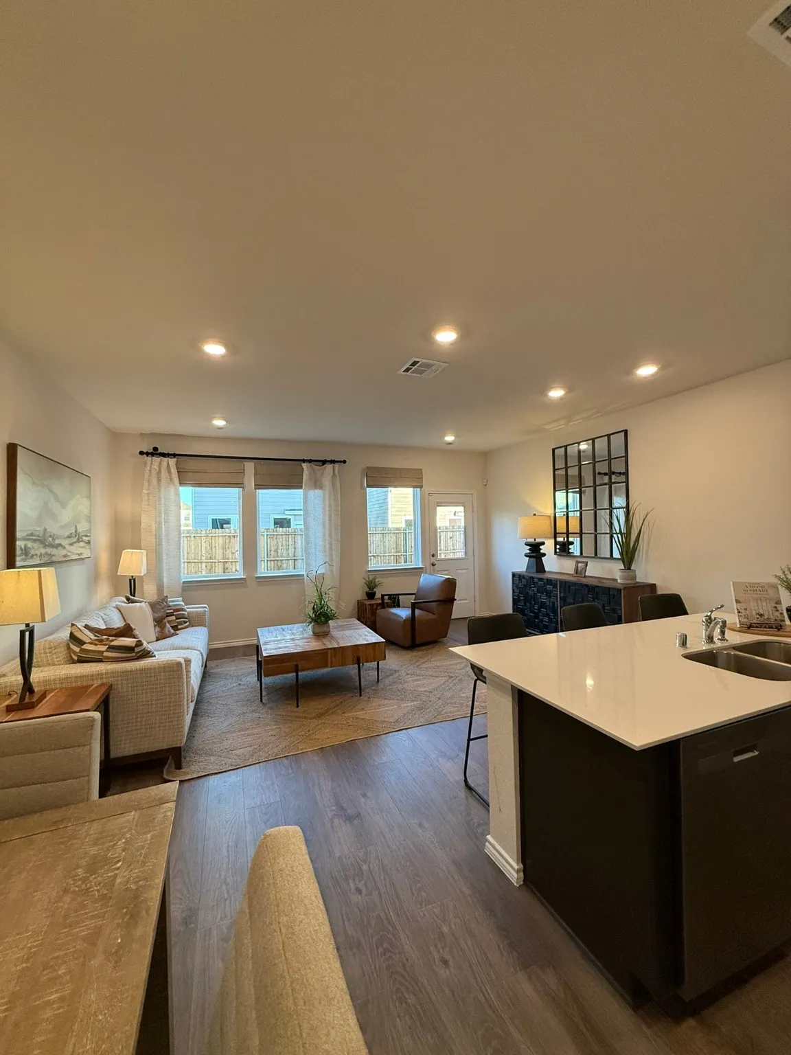 Kitchen with open floor plan, dark wood-style flooring, recessed lighting, a breakfast bar, and a center island with sink