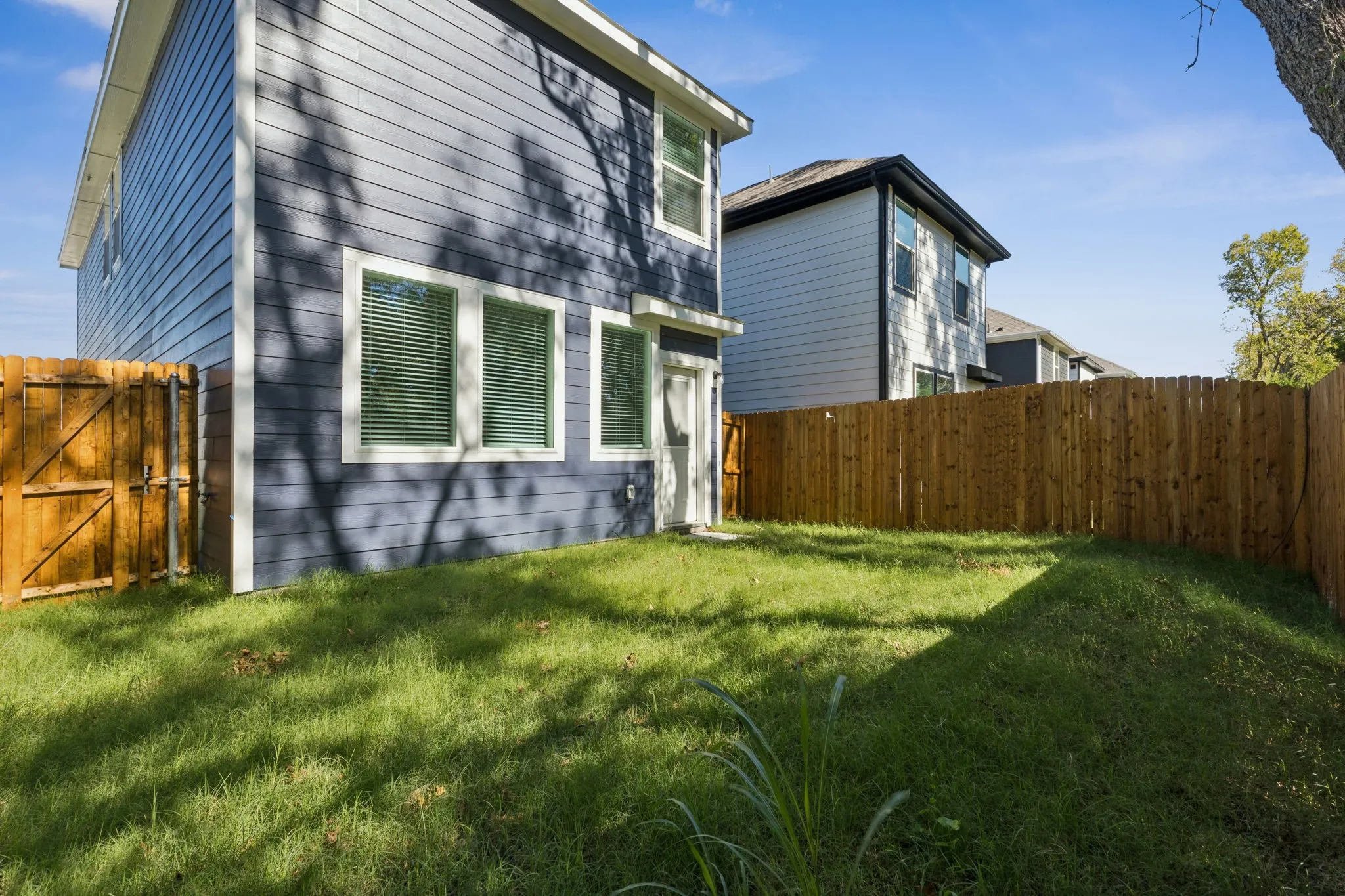 View of property exterior with a fenced backyard and a gate