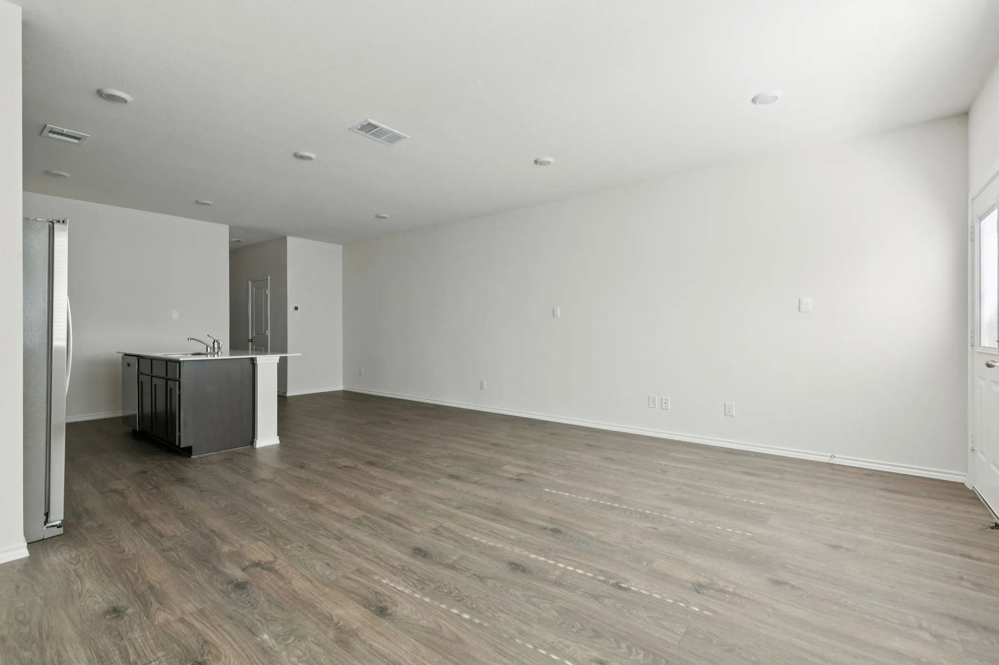 Unfurnished living room featuring dark wood-type flooring and baseboards