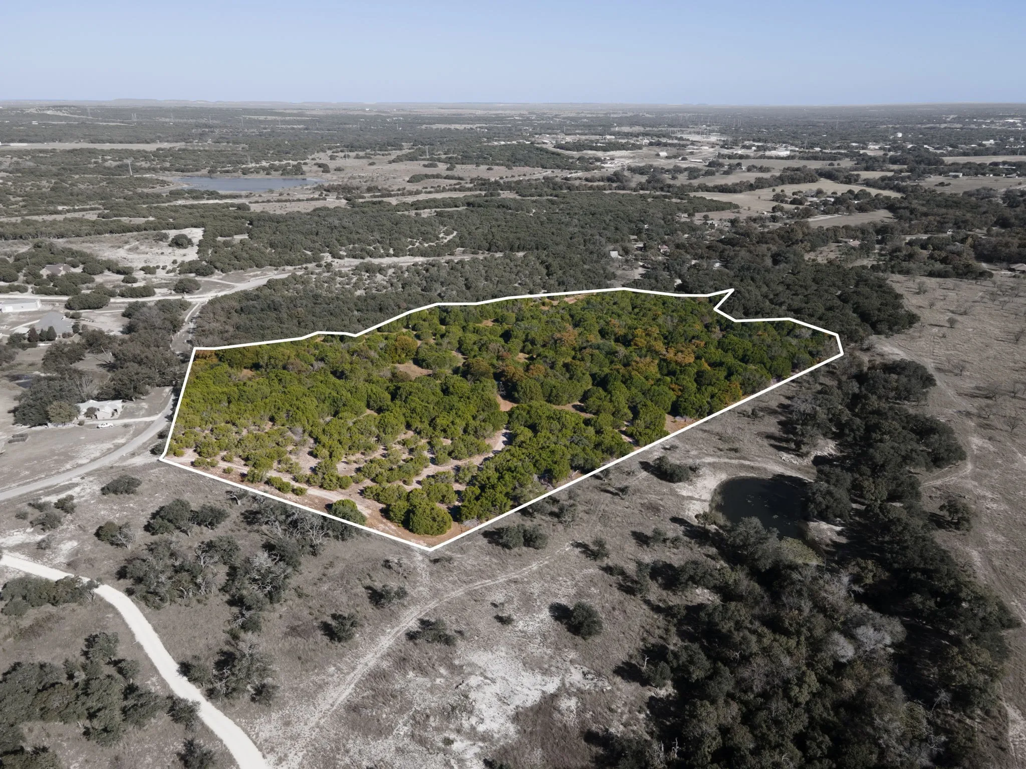 Aerial view of property's location with a large body of water and property boundaries highlighted
