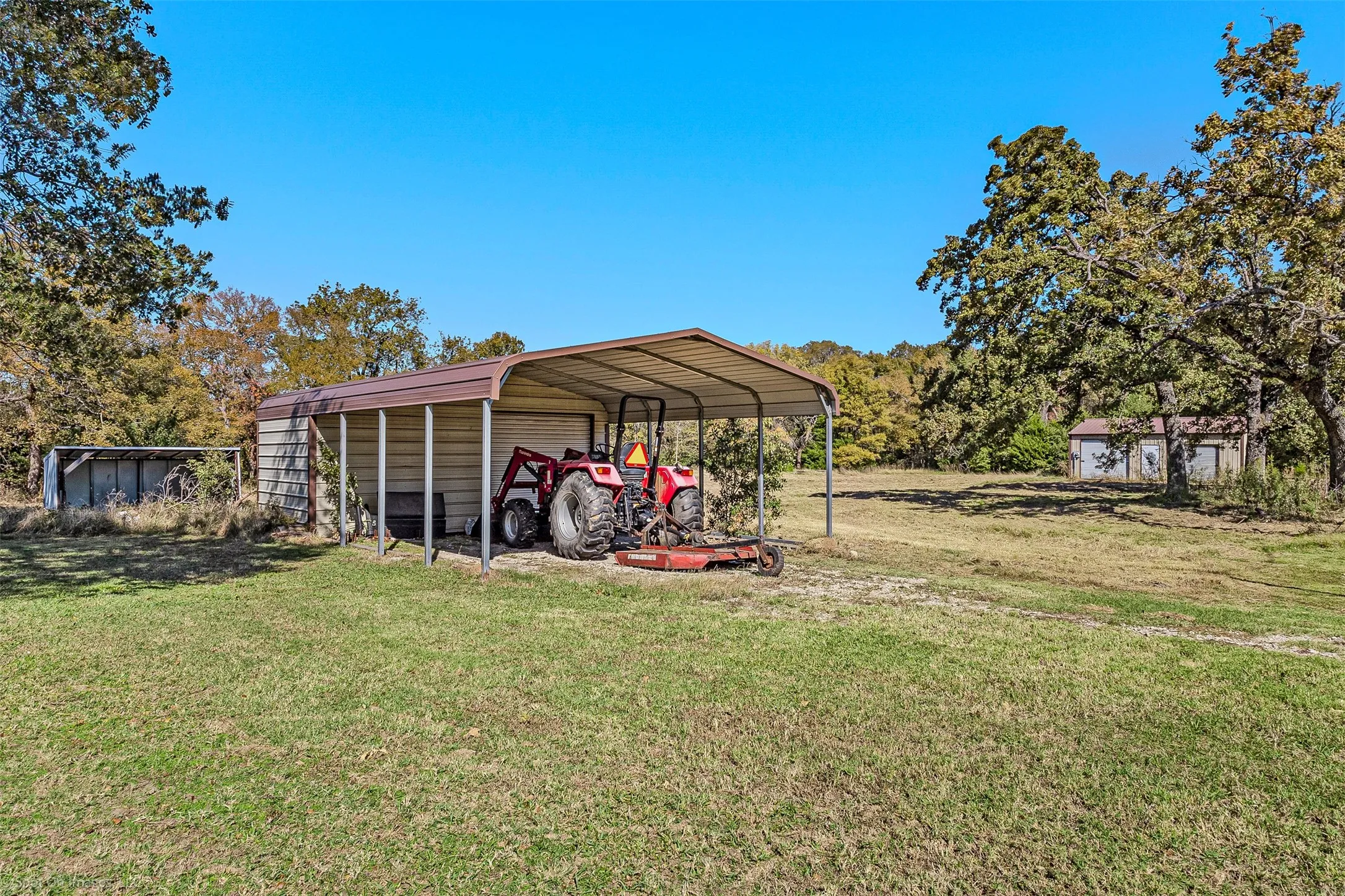 View of green lawn with an outdoor structure and a detached garage