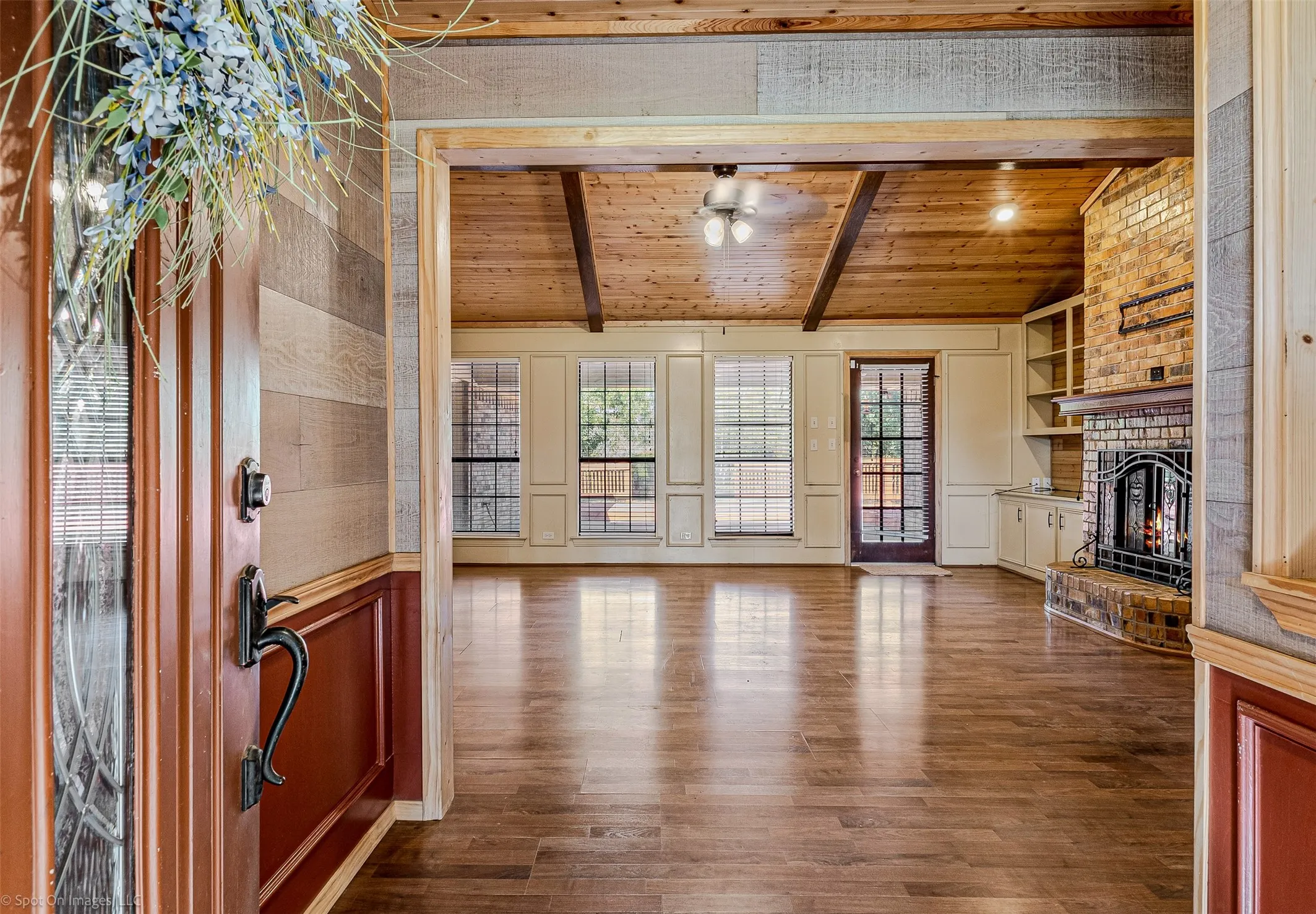 Unfurnished living room featuring dark wood-style flooring, wood ceiling, a fireplace, and a ceiling fan