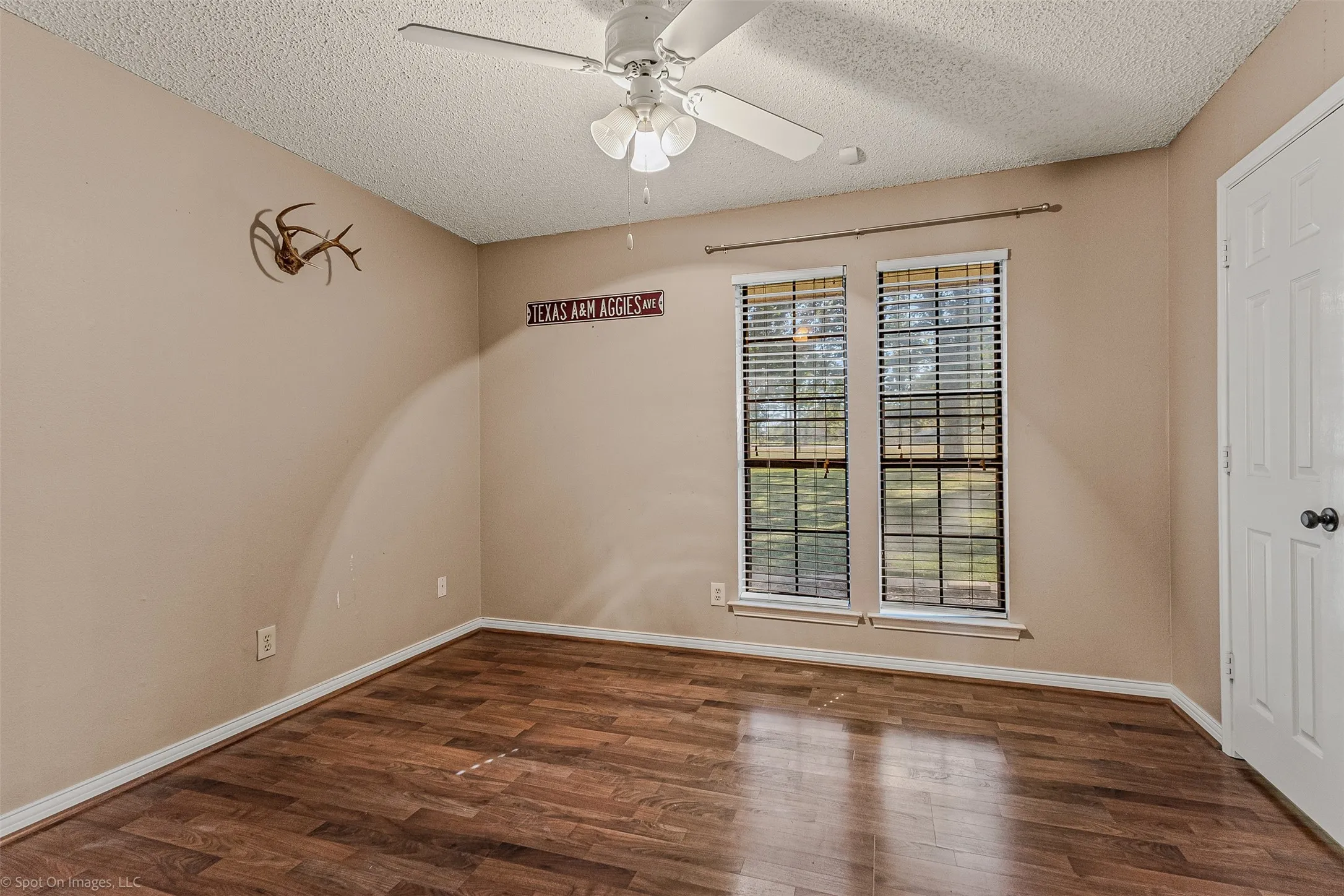 Spare room featuring dark wood finished floors, a textured ceiling, and ceiling fan