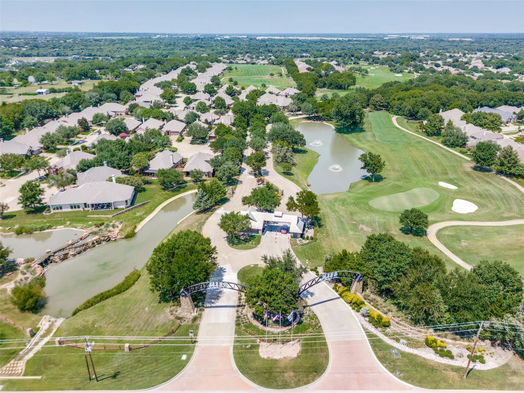 Aerial view of front gate property's location with a nearby body of water and nearby suburban area