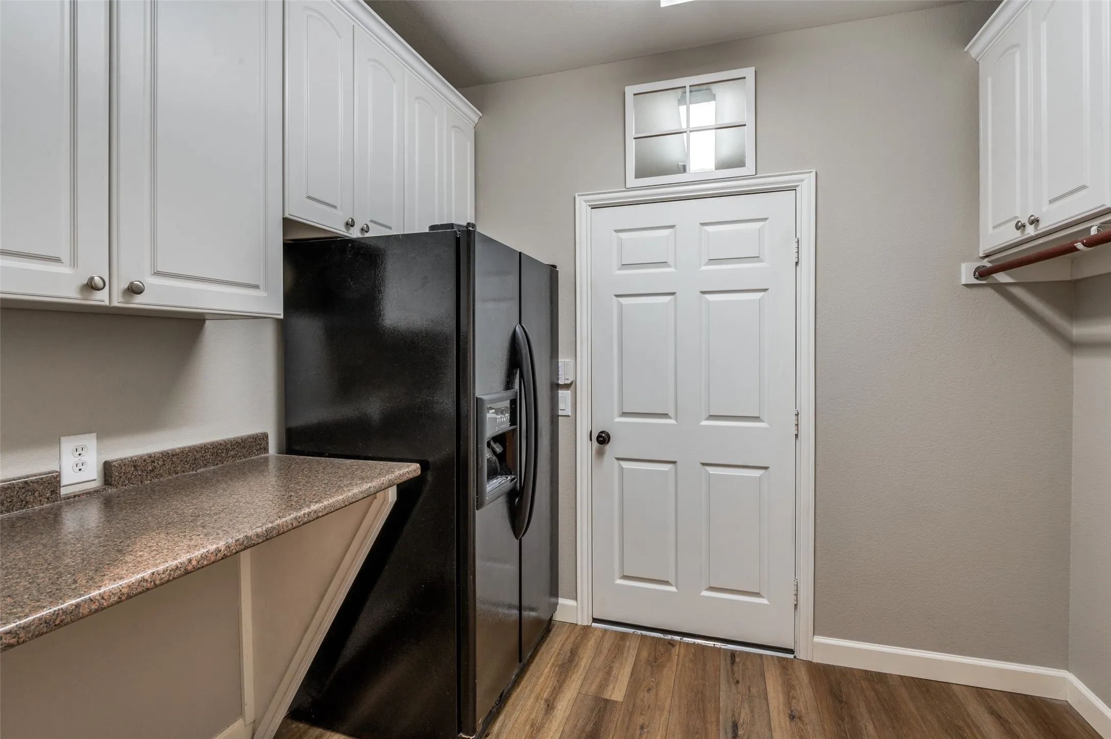 Laundry room with dark wood finished floors and baseboards