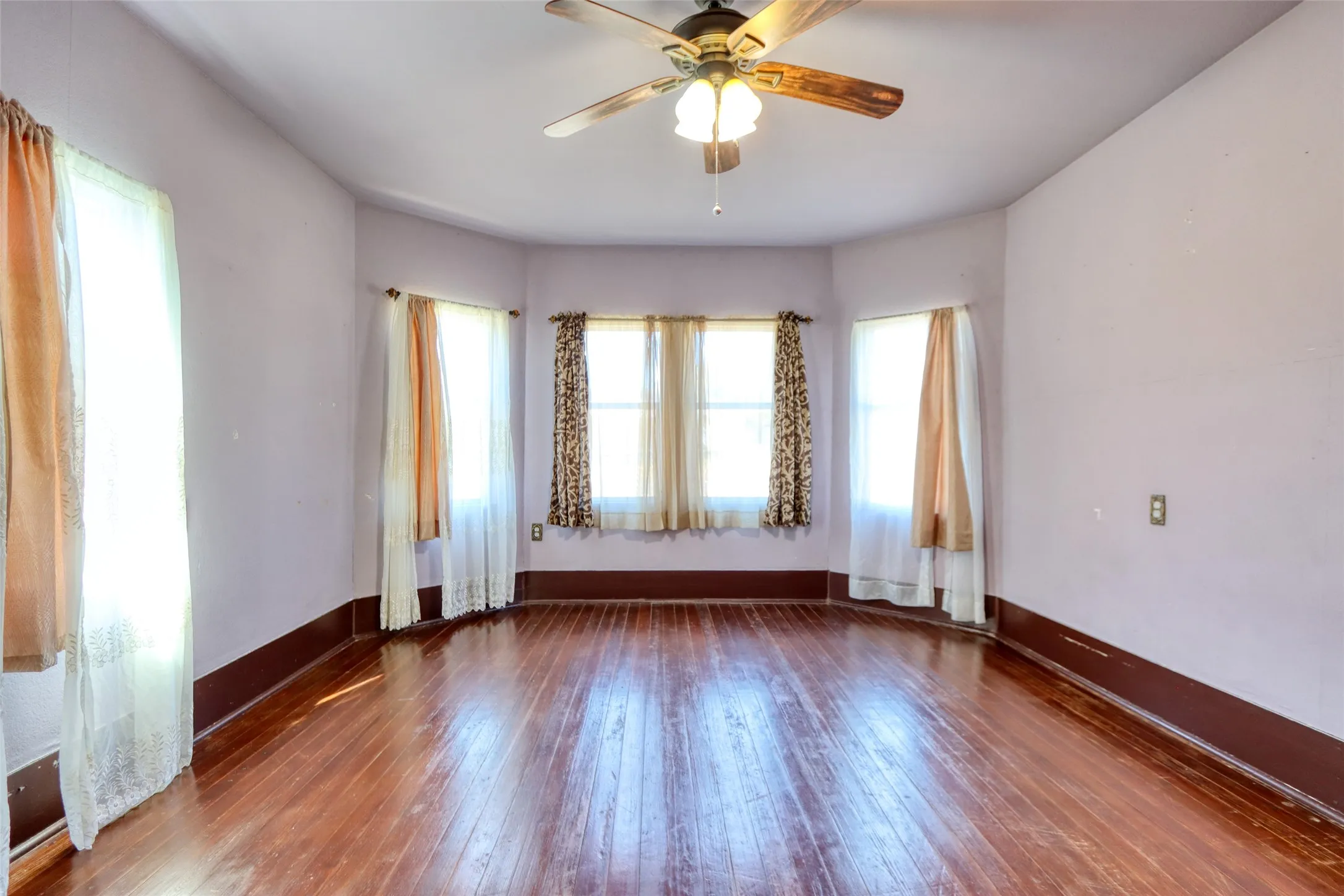 Living area featuring dark wood finished floors and ceiling fan