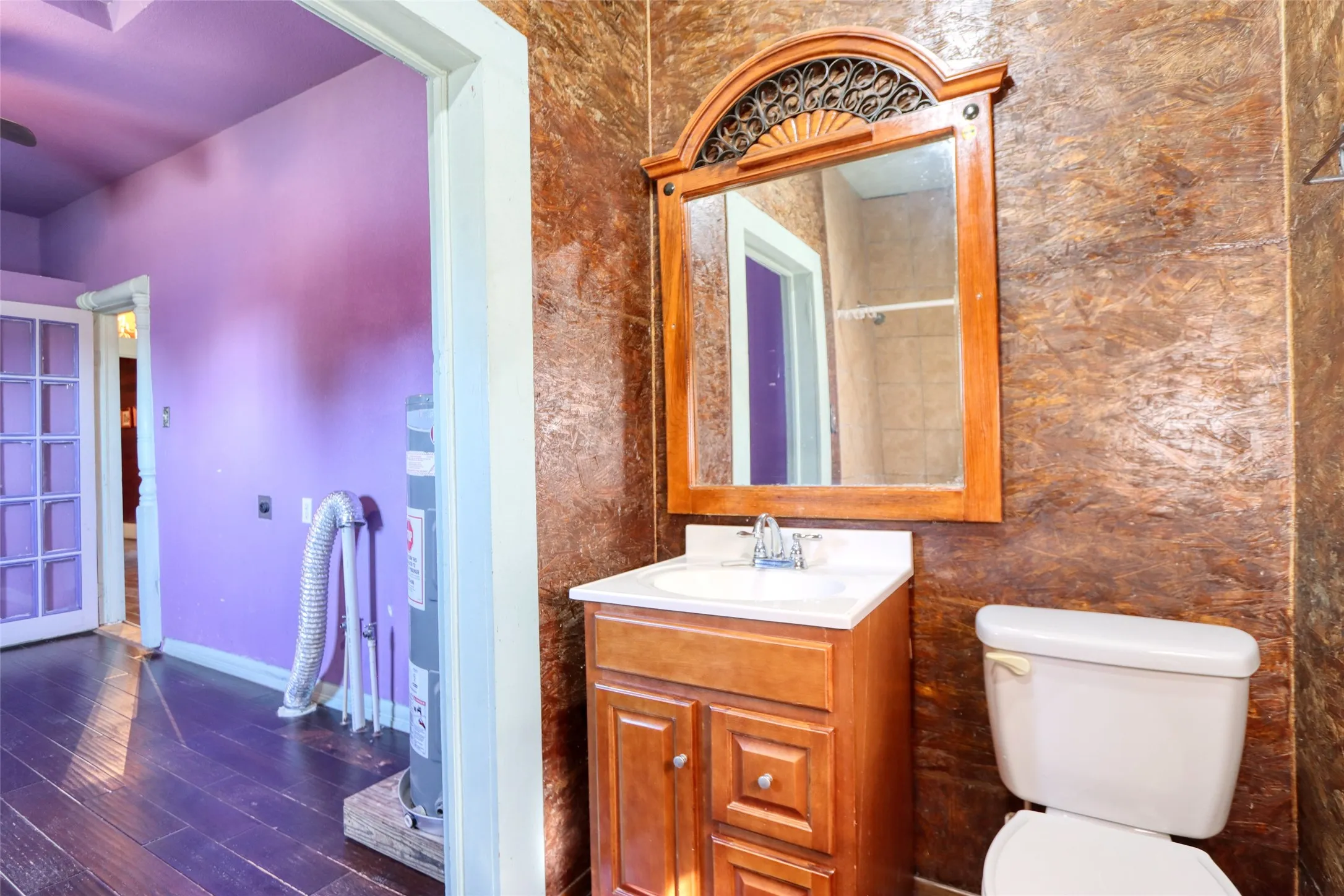 Bathroom with vanity, dark wood-type flooring, and electric water heater