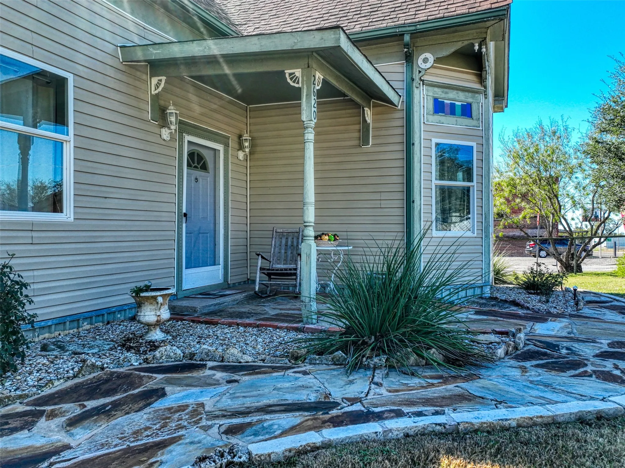 Entrance to property with roof with shingles and covered porch