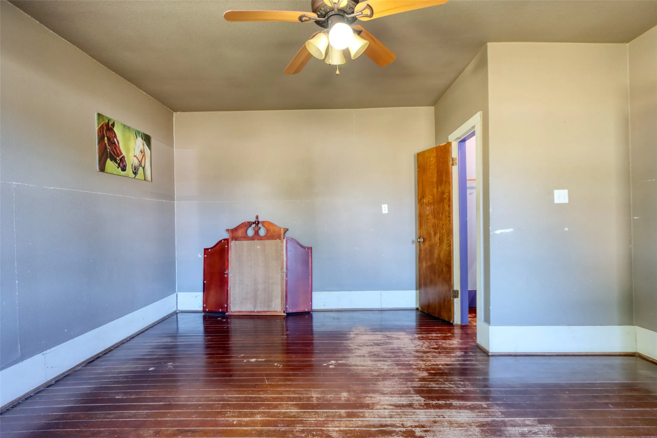 Primary room with dark wood-style flooring and a ceiling fan