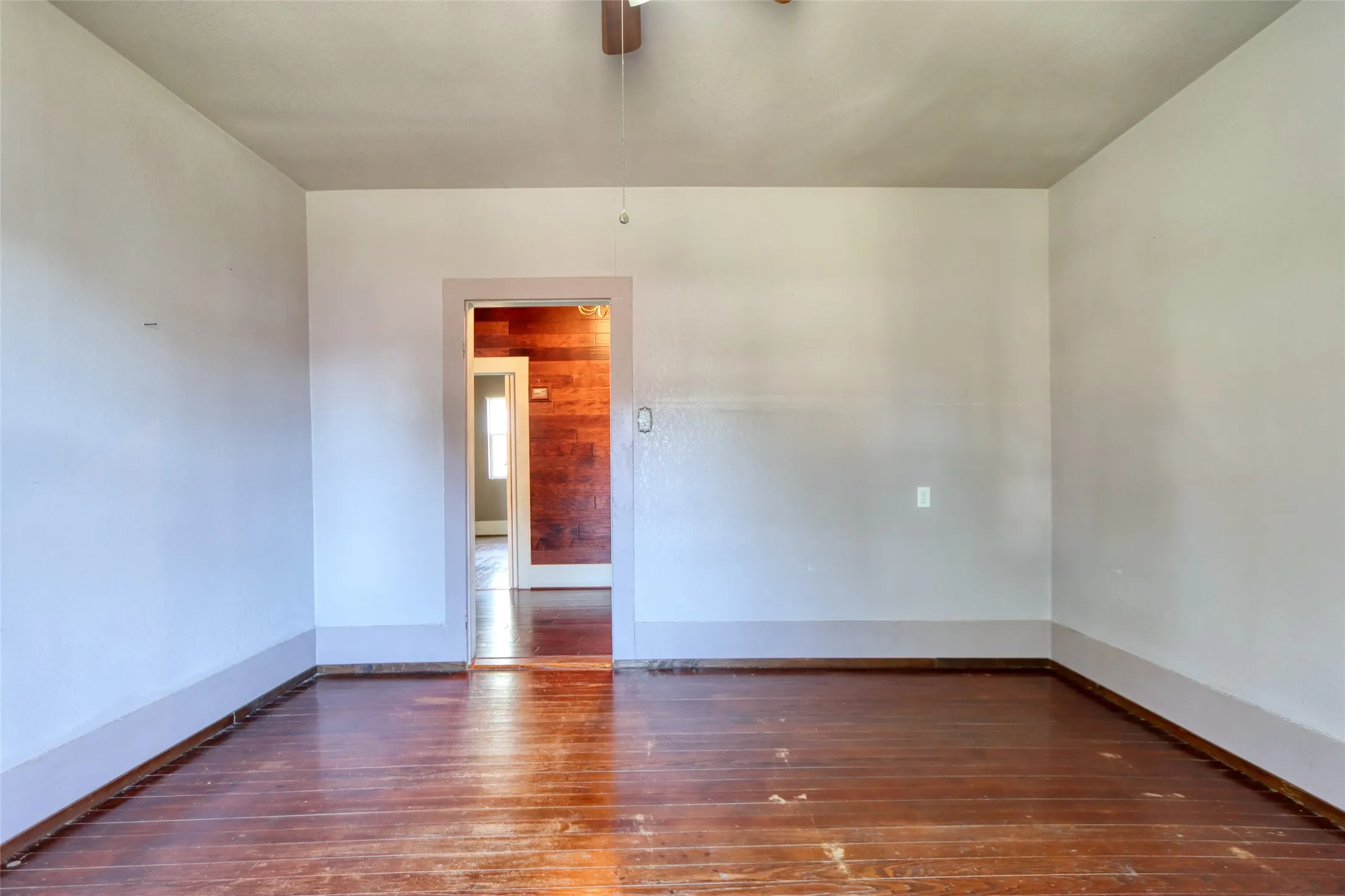 Bedroom 2 view with dark wood-style floors and a ceiling fan
