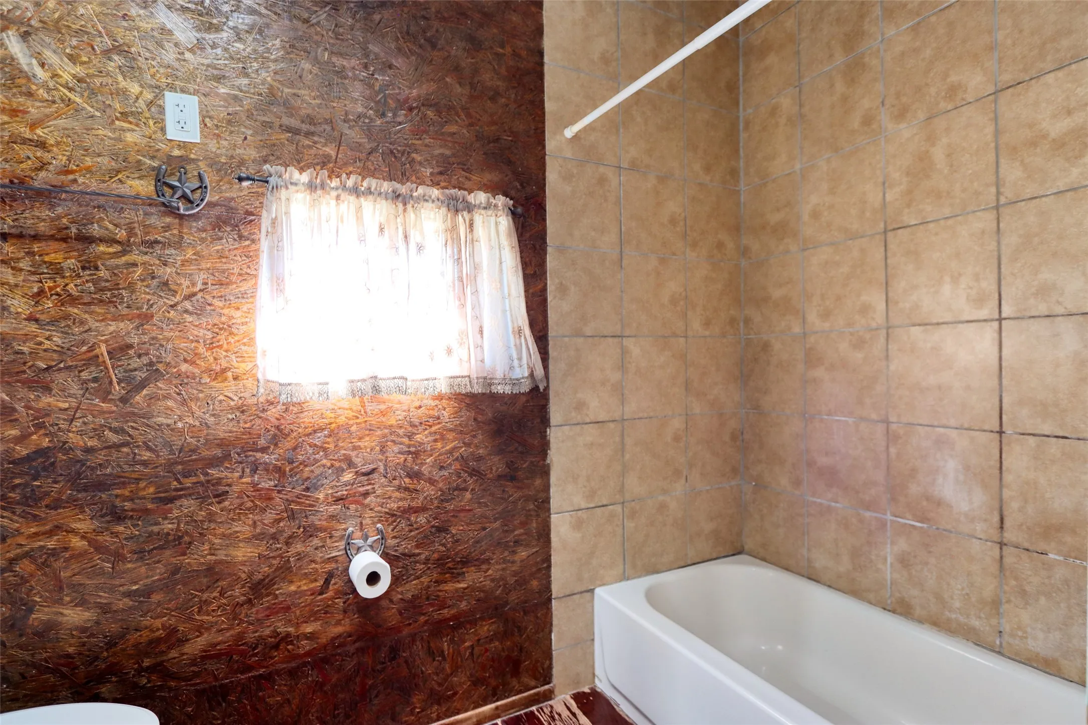 Bathroom featuring bathing tub / shower combination and tile walls