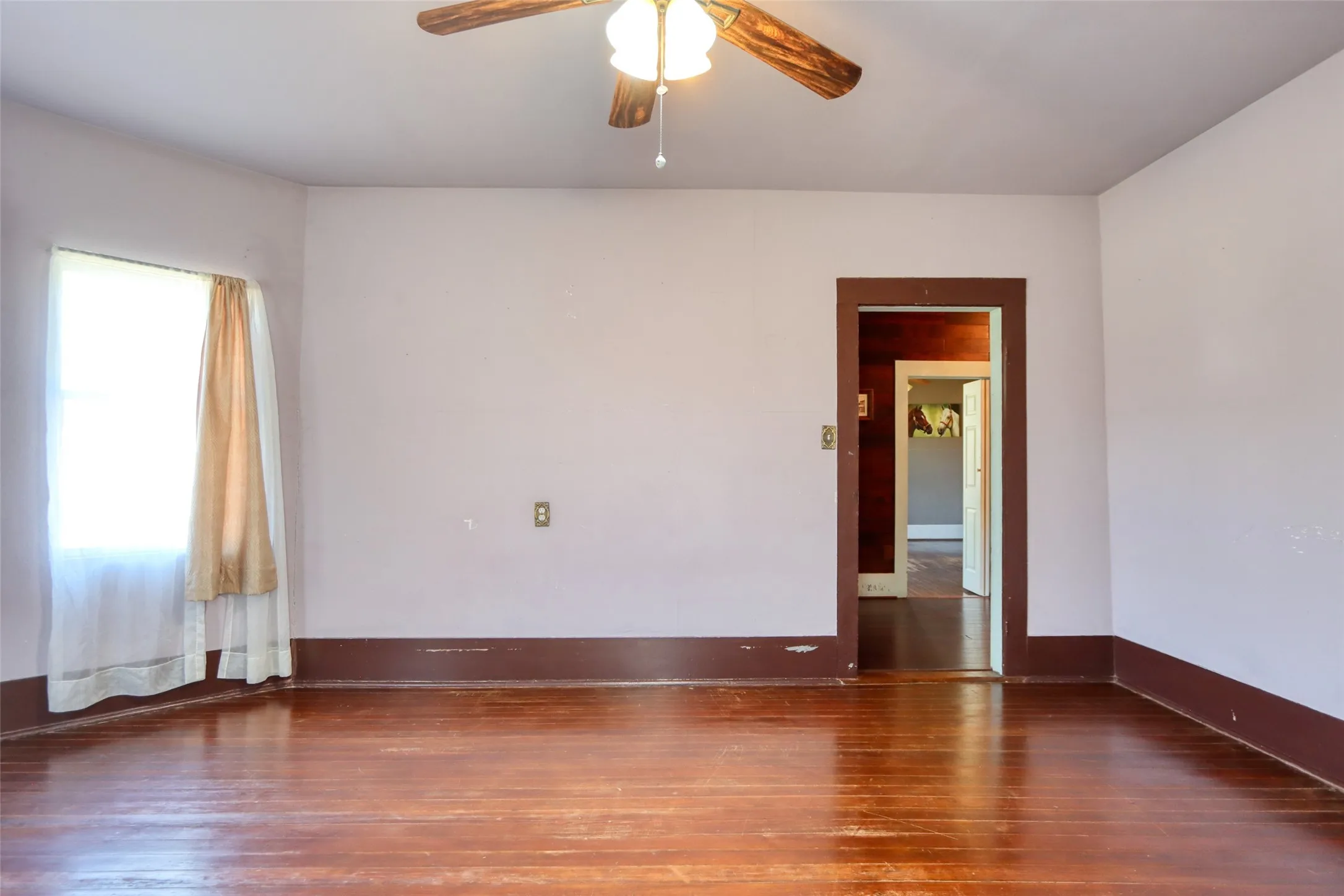 Living area featuring dark wood-style floors and a ceiling fan
