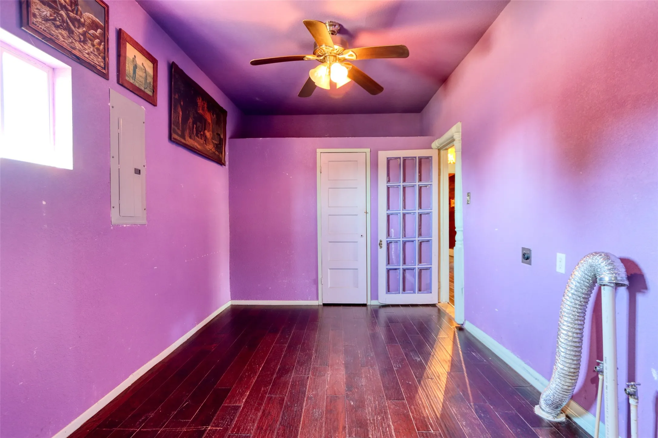 Extra room with a ceiling fan, dark wood-type flooring, and electric panel