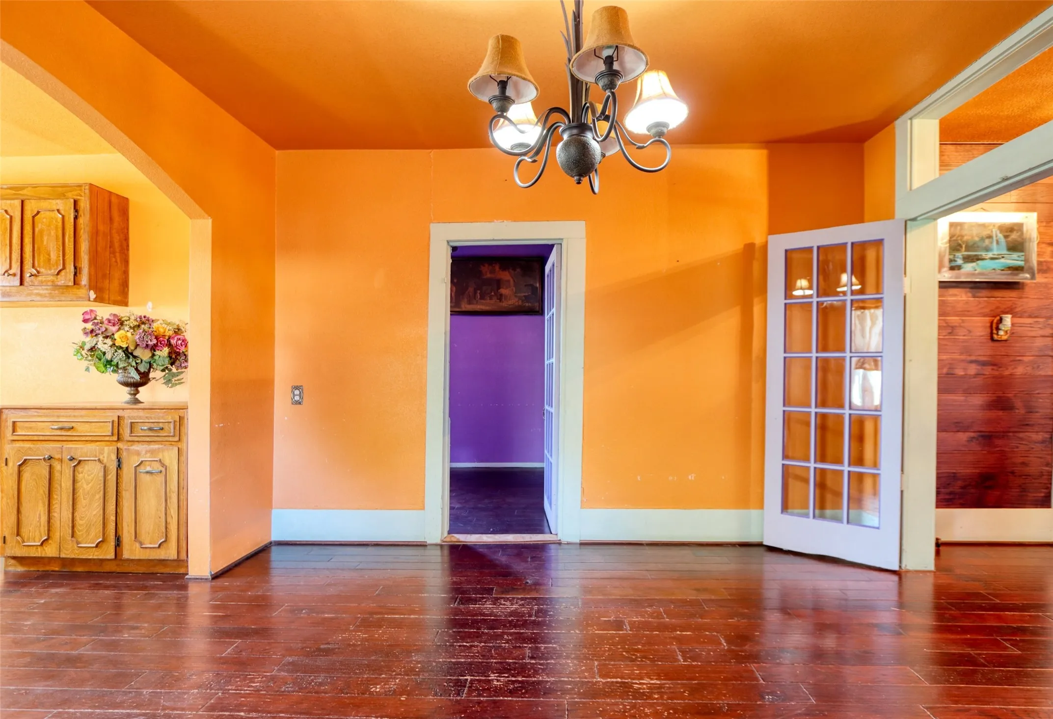 Unfurnished dining area with dark wood-type flooring, arched walkways, and a chandelier