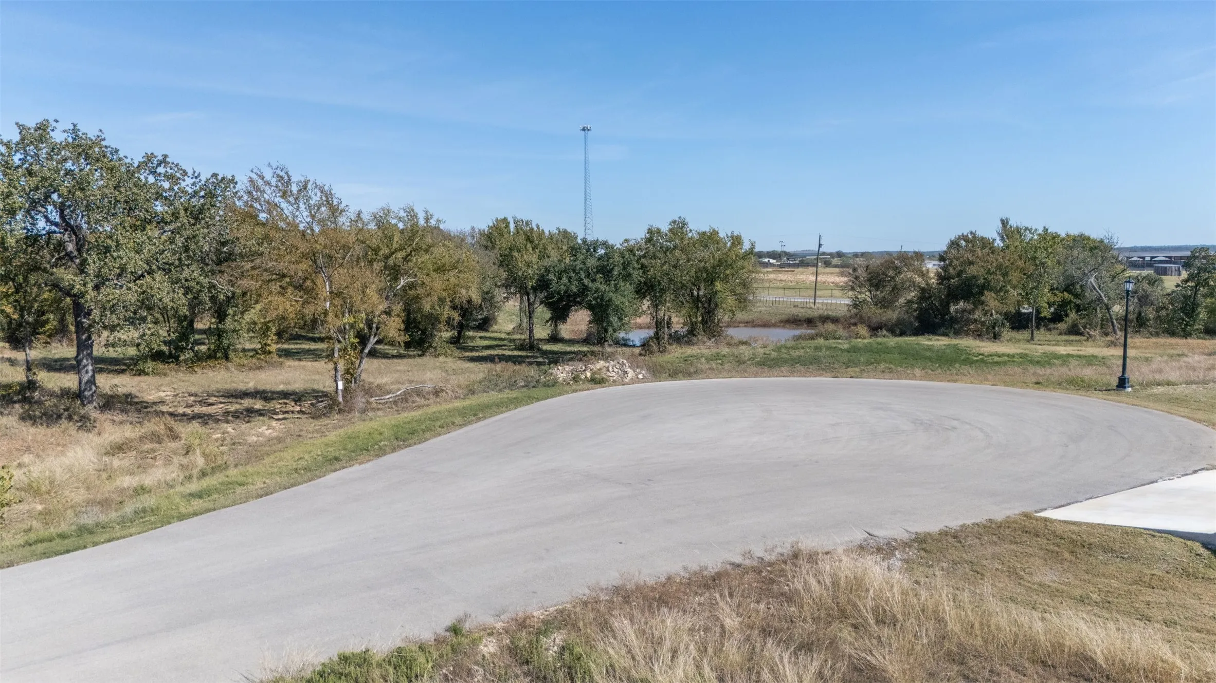 View of asphalt road with view of wooded area and a view of rural / pastoral area