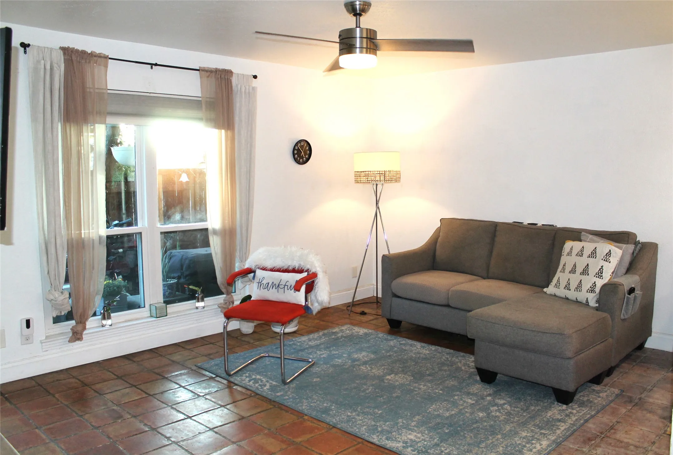 Living area with a ceiling fan and baseboards