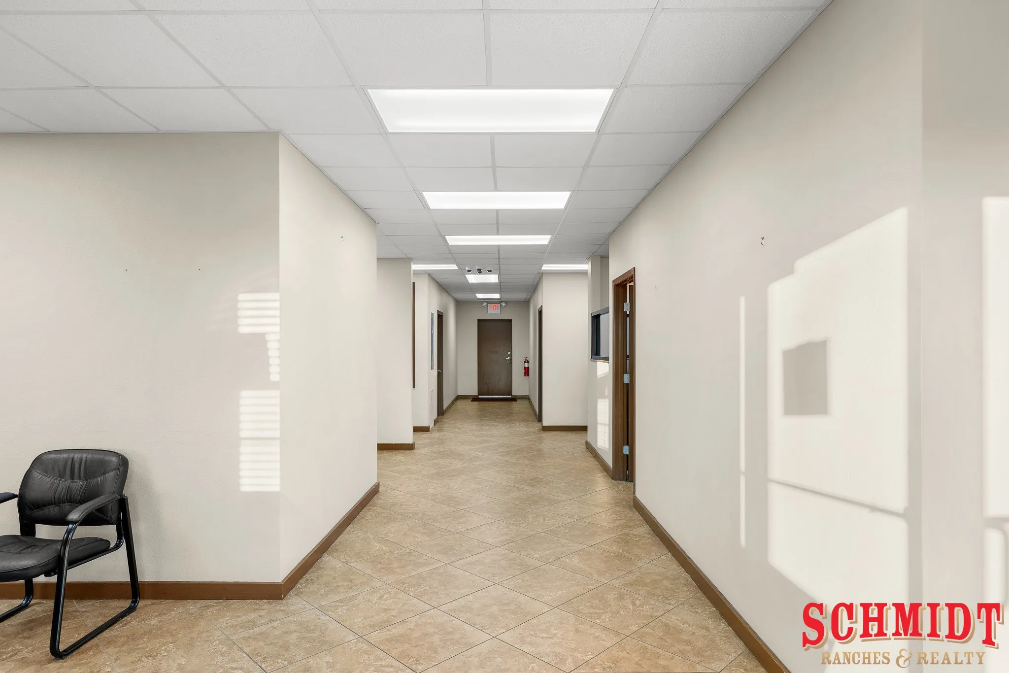 Hallway with tiled flooring, neutral wall tones, drop ceiling, and recessed lighting