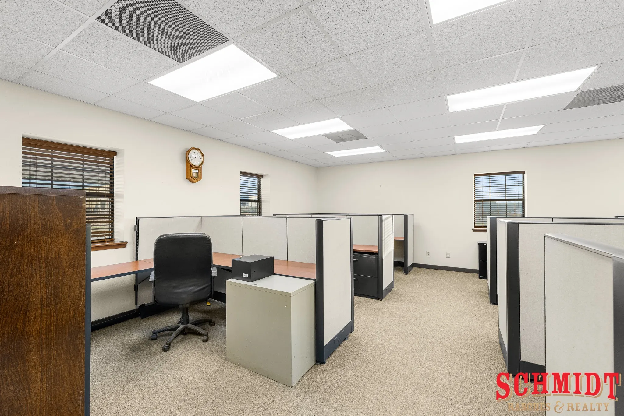 Office space featuring multiple workstations, recessed lighting, drop ceiling, and carpeted flooring