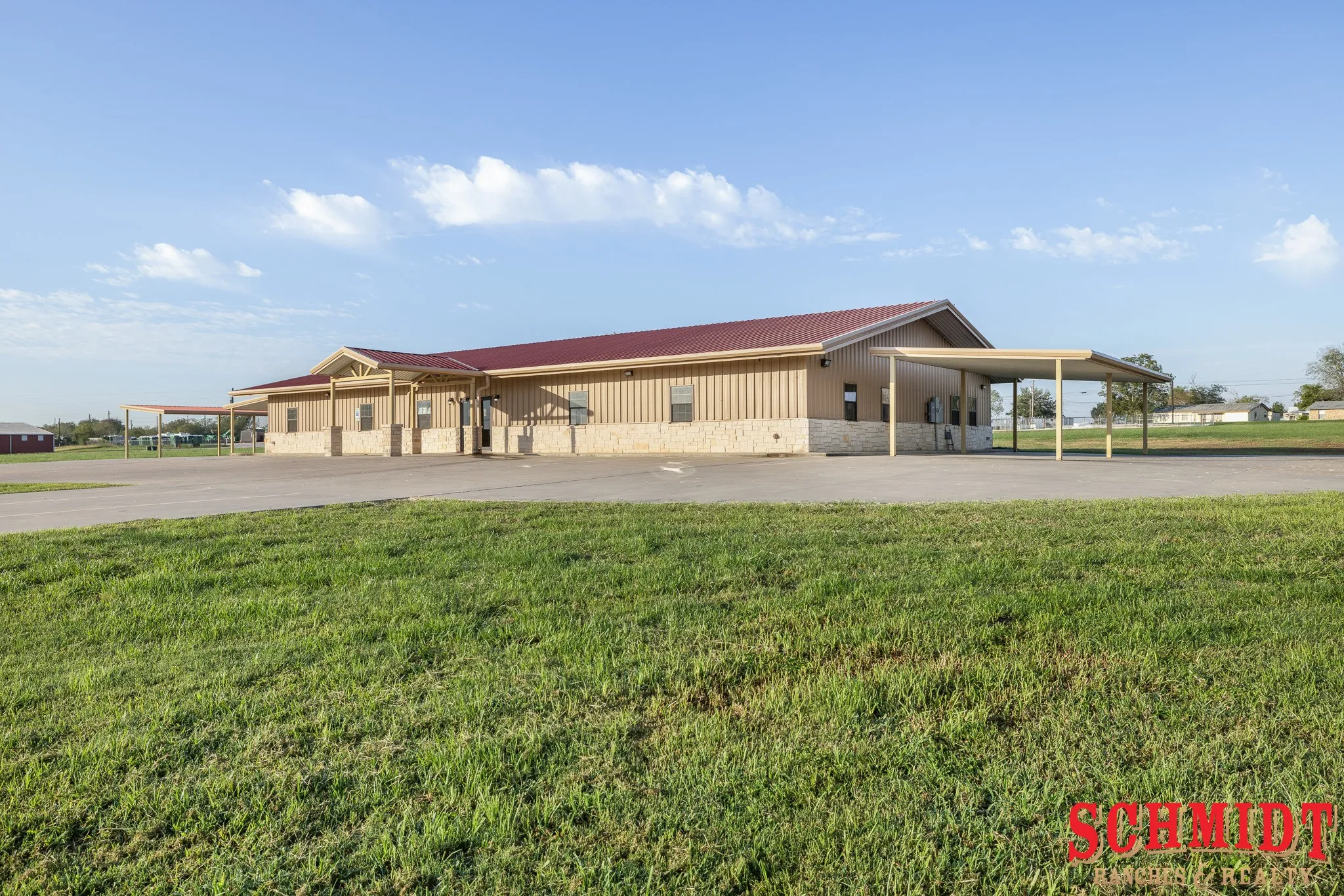 Commercial structure featuring a metal roof, a stone and corrugated siding exterior, and multiple covered entryways