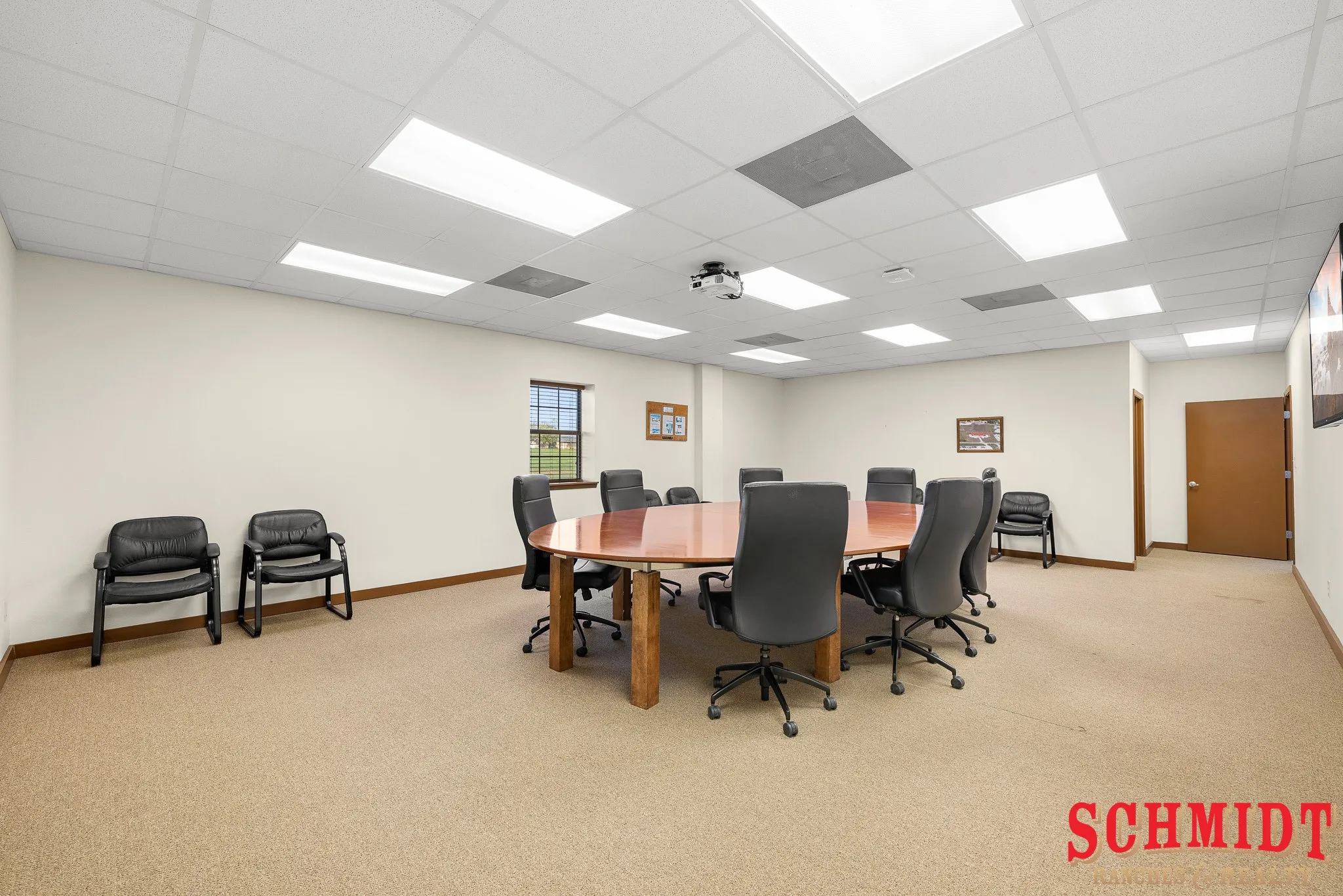 Recessed lighting, drop ceiling, and carpeted flooring in a spacious room with a window