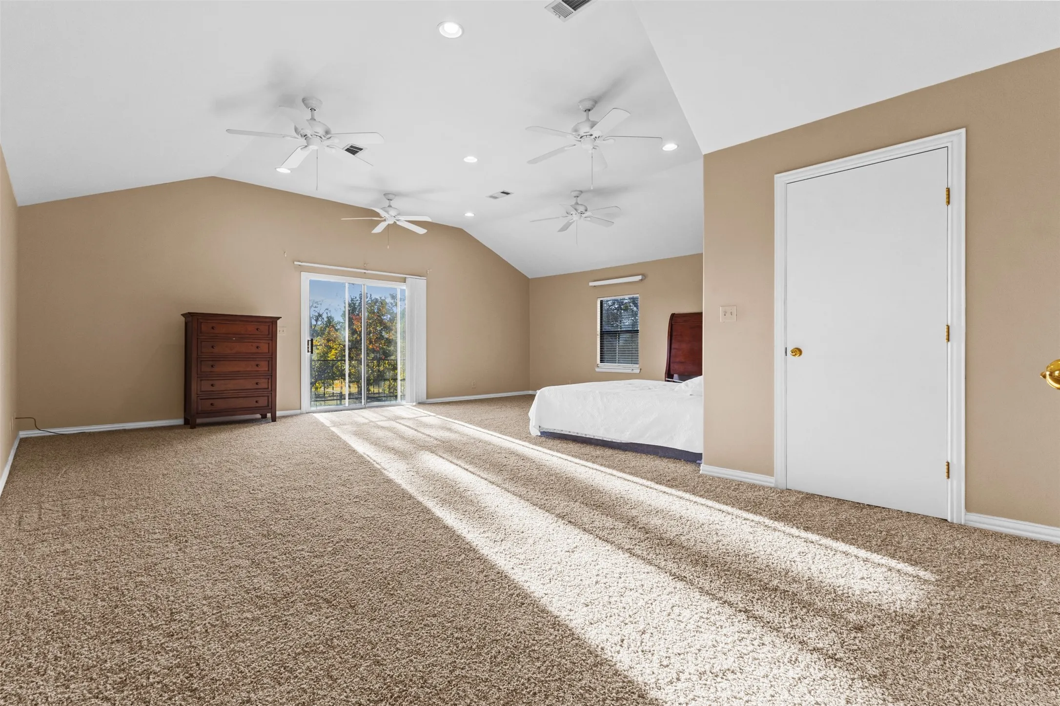 Unfurnished bedroom featuring access to outside, carpet floors, lofted ceiling, and recessed lighting