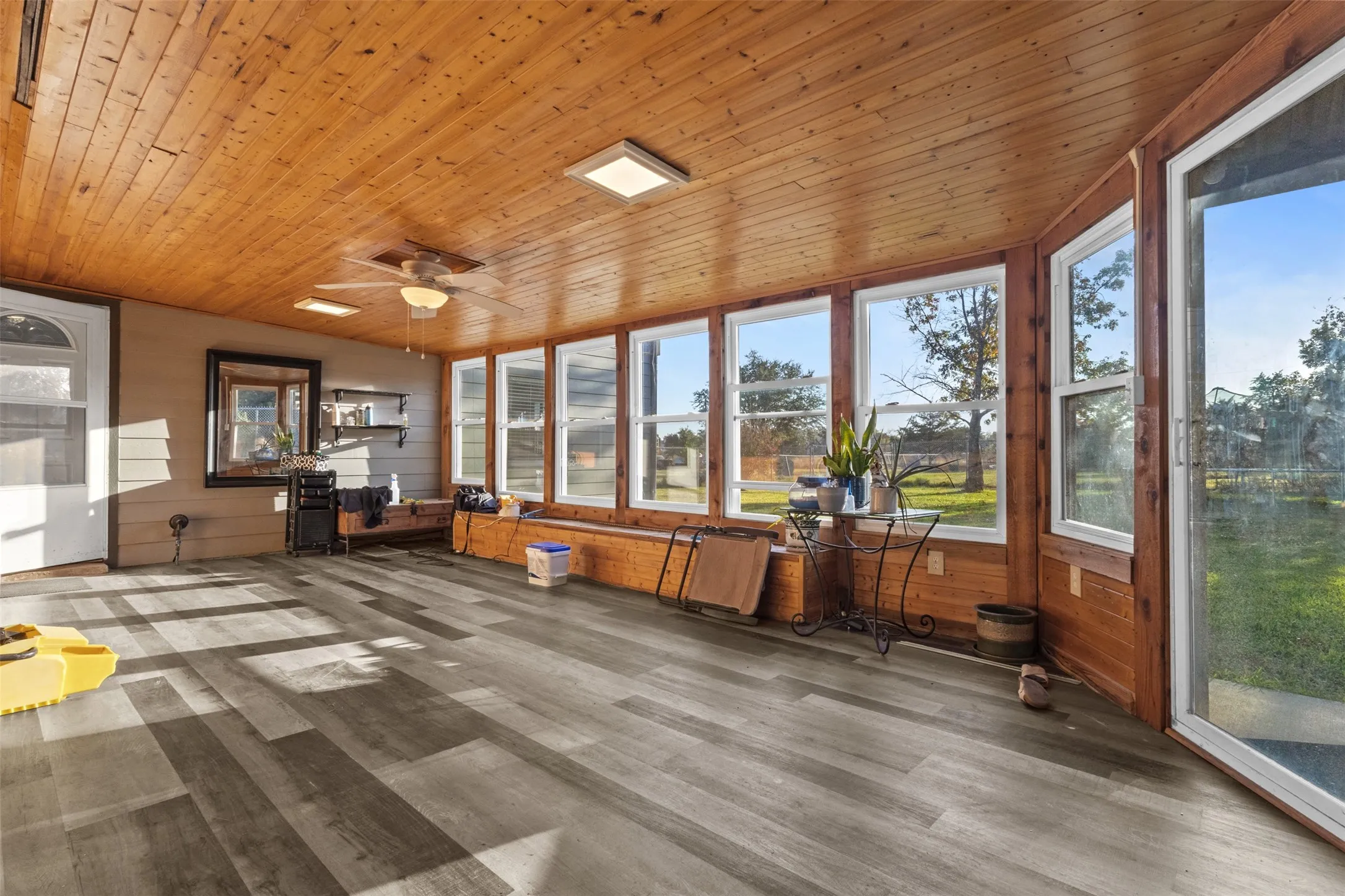 Unfurnished sunroom with wood finished floors, wood ceiling, and wooden walls
