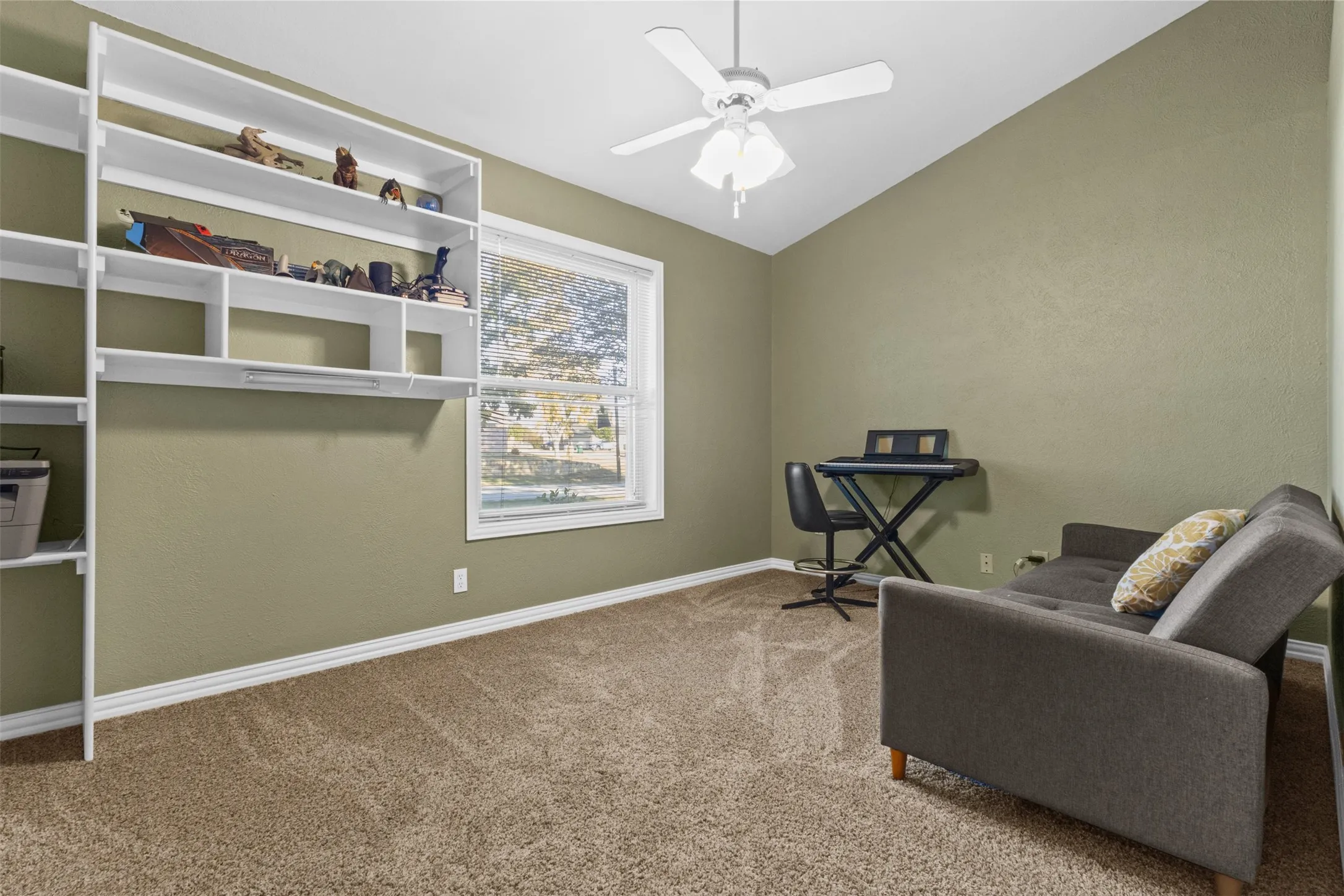 Living area with vaulted ceiling, carpet, and ceiling fan