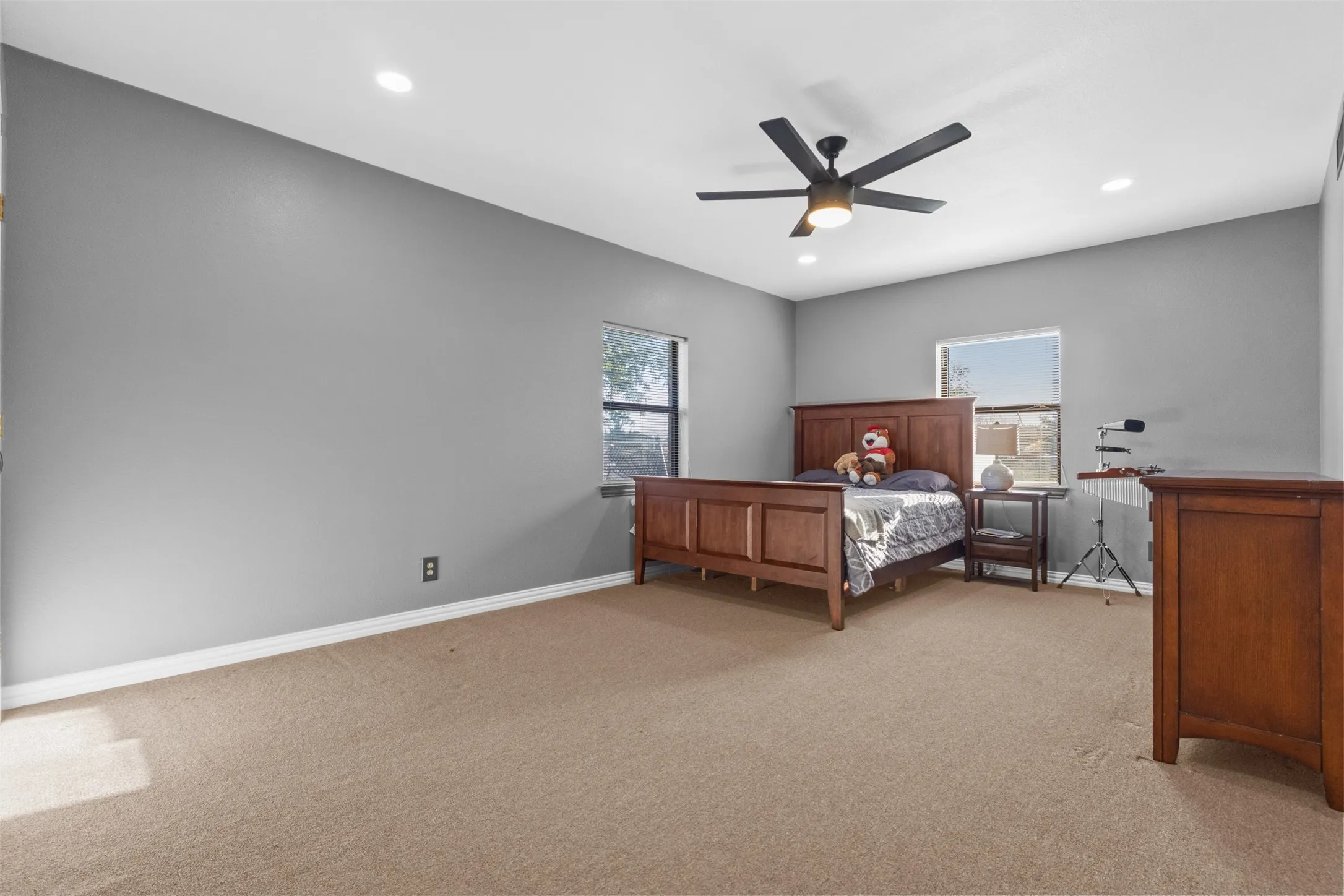 Bedroom featuring light colored carpet, multiple windows, a ceiling fan, and recessed lighting