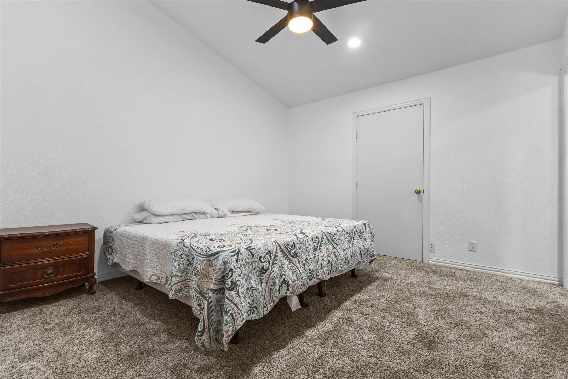 Bedroom with vaulted ceiling, carpet, and ceiling fan