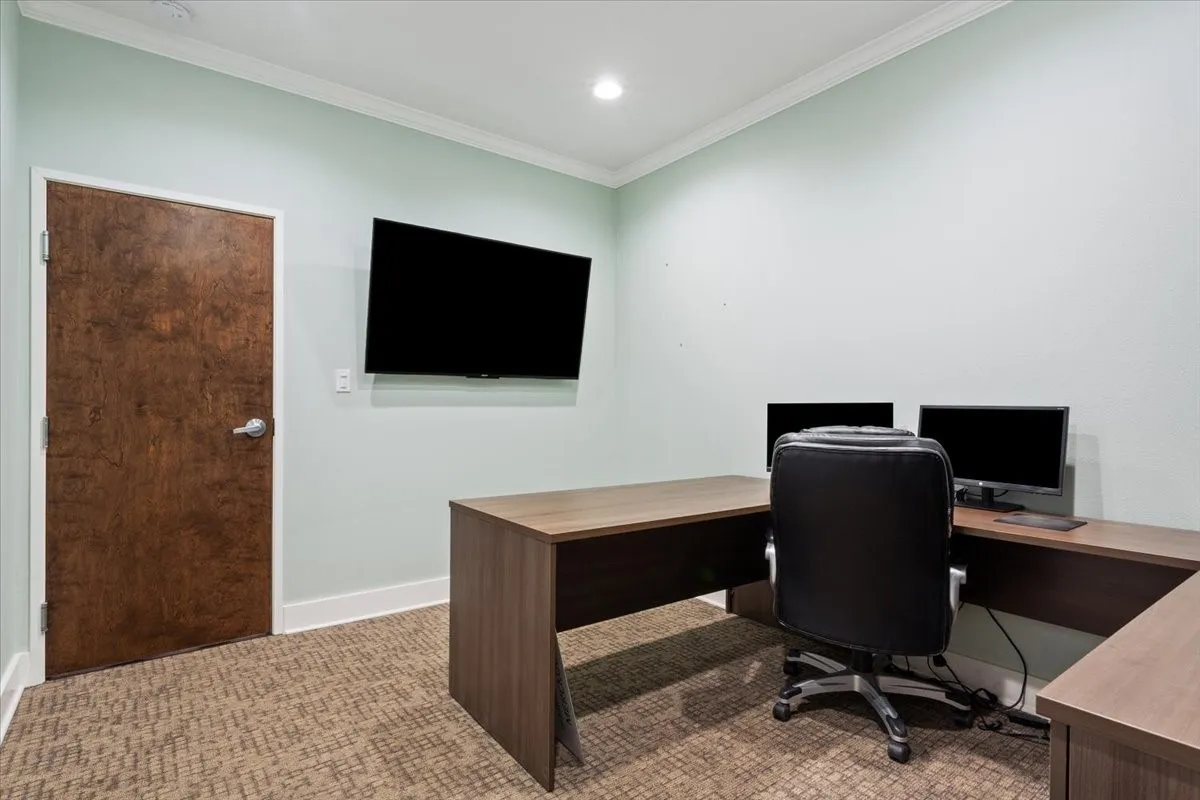 Carpeted home office with ornamental molding and recessed lighting