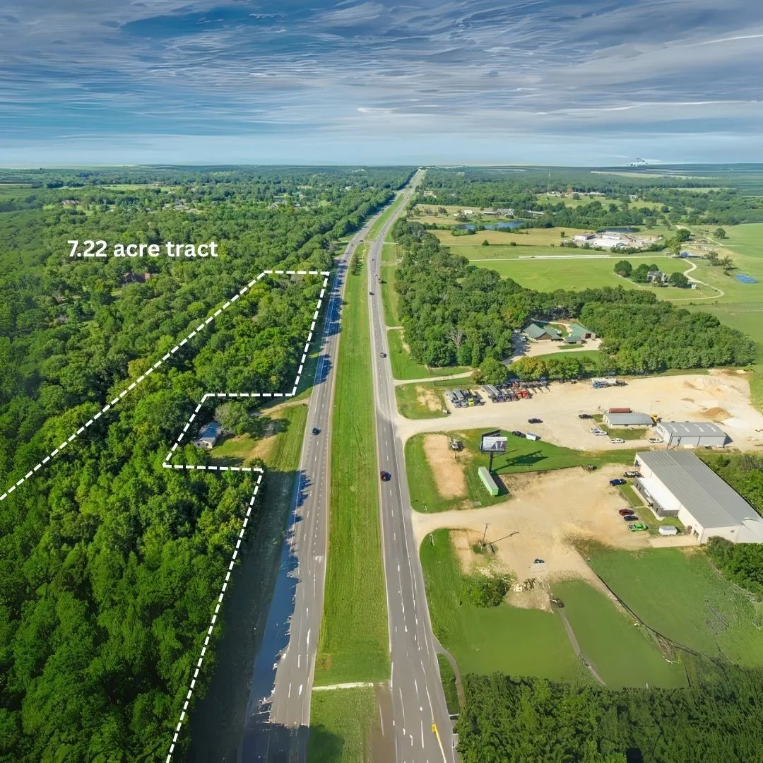 Aerial view of property and surrounding area with property boundaries highlighted and a major roadway