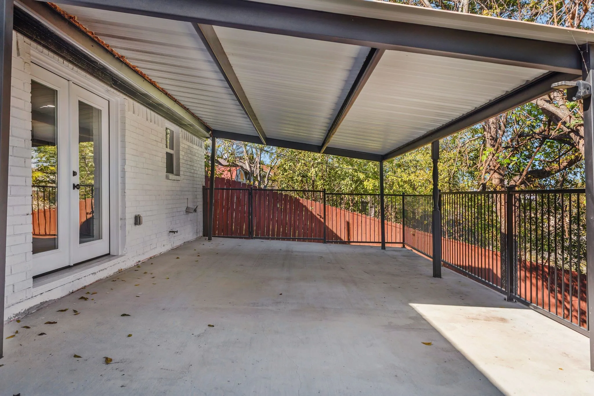 View of patio with a carport, a gate, and french doors
