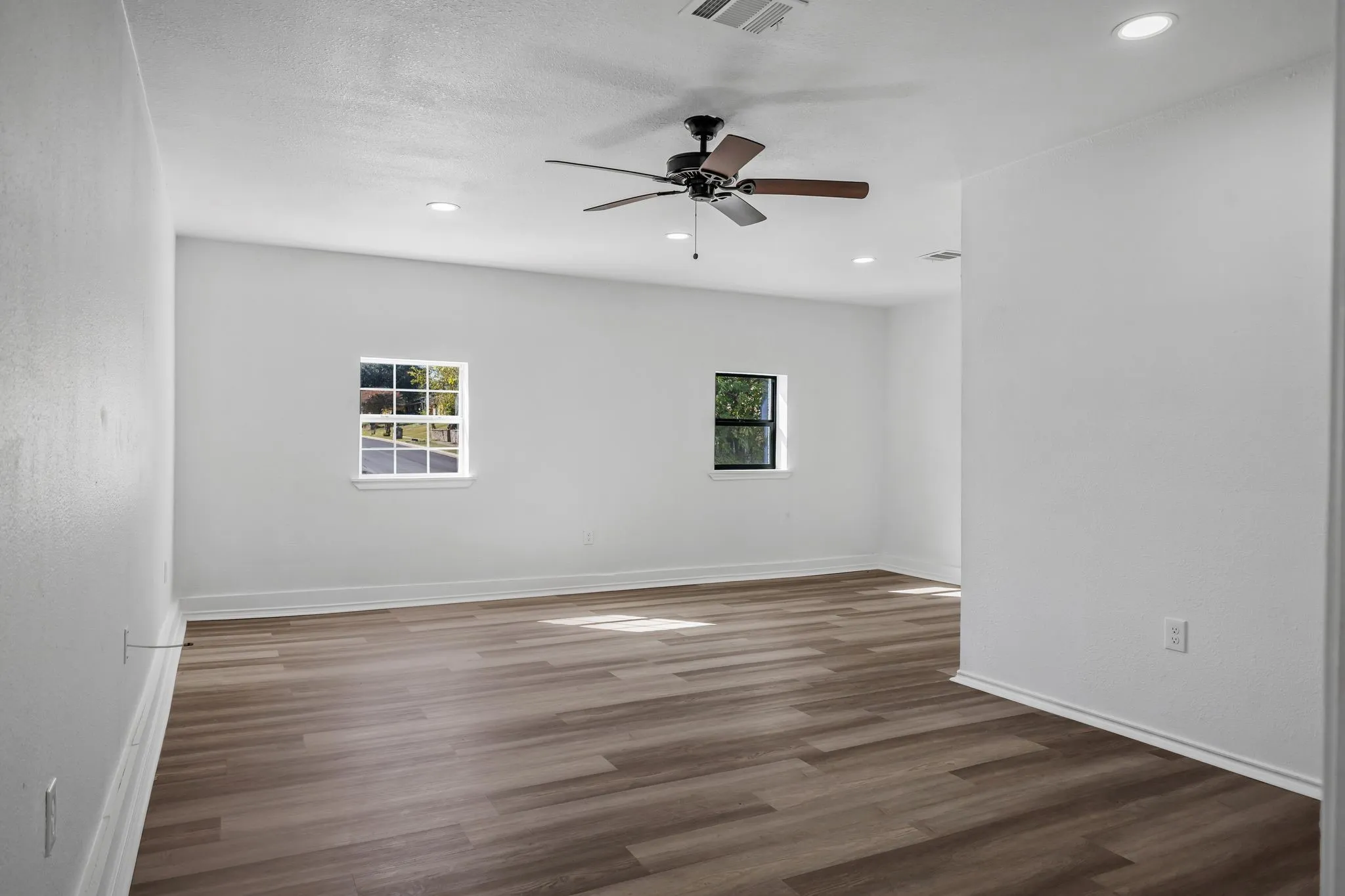 Empty room featuring dark wood-style flooring, recessed lighting, and a ceiling fan