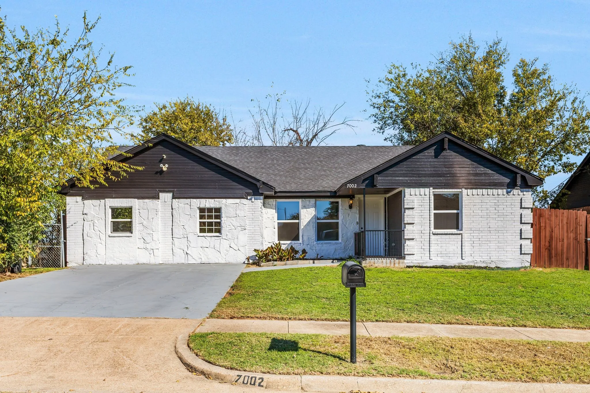 Ranch-style house featuring concrete driveway and covered porch