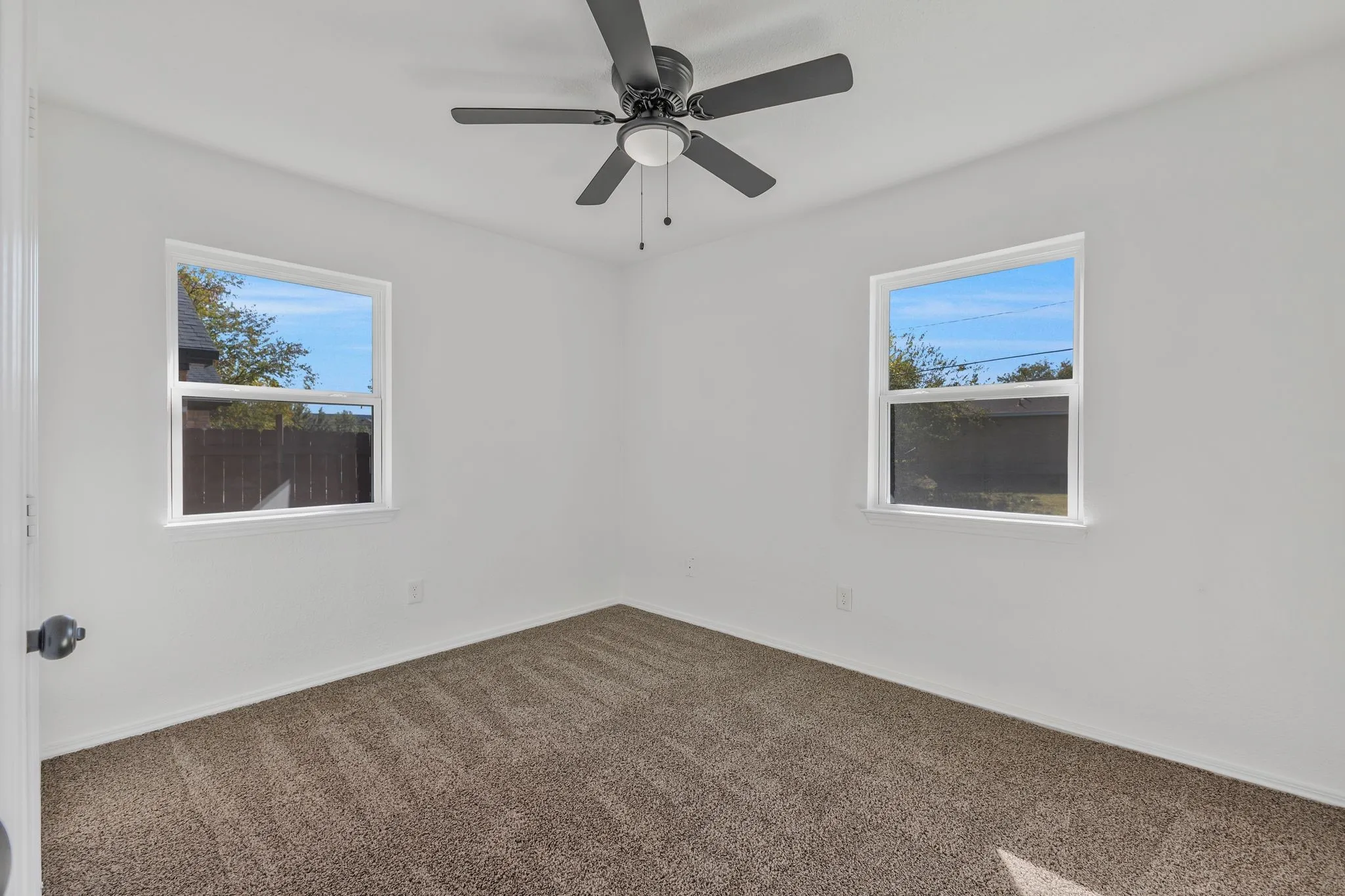 Empty room featuring carpet and a ceiling fan