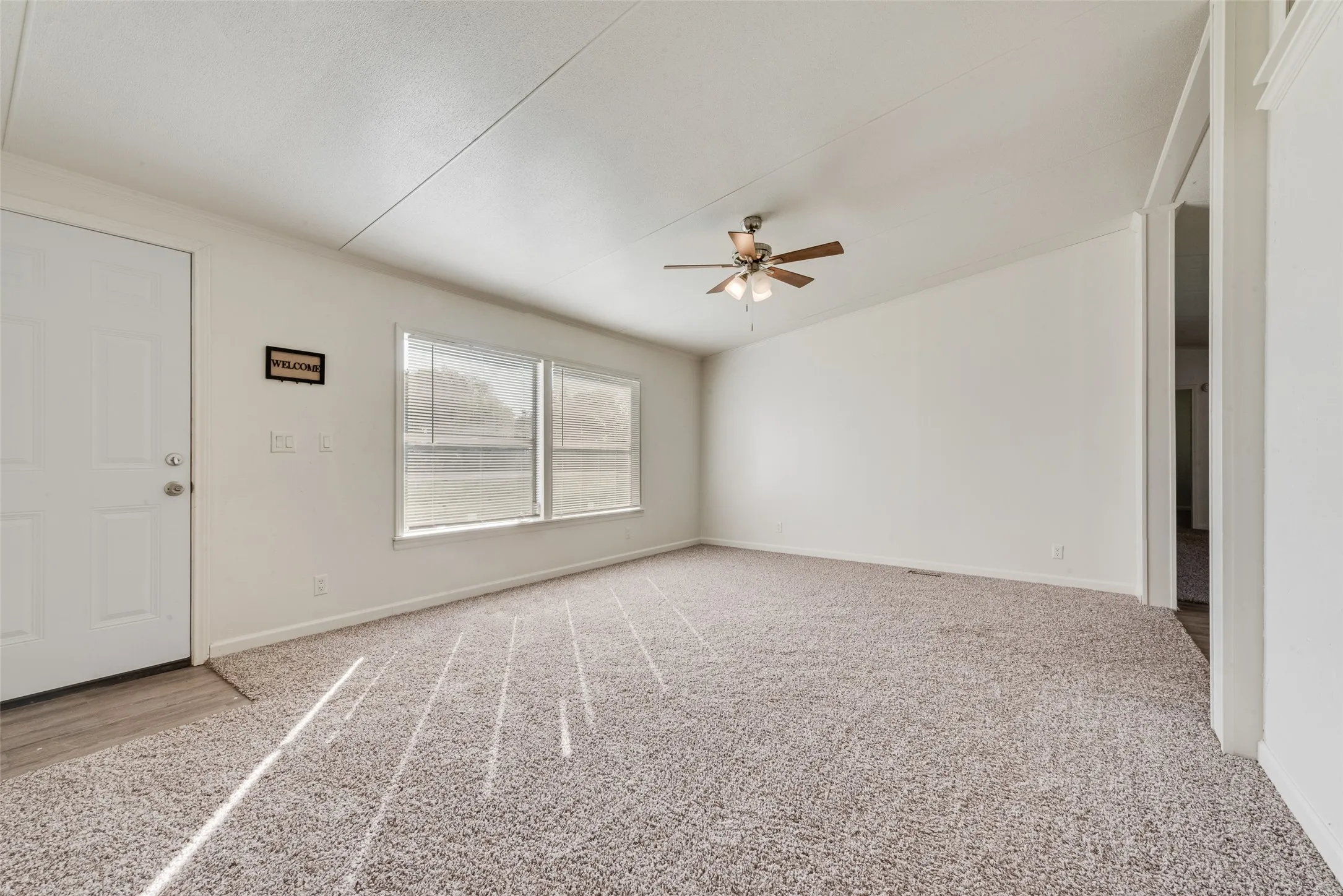 Unfurnished room featuring light carpet, a ceiling fan, and lofted ceiling
