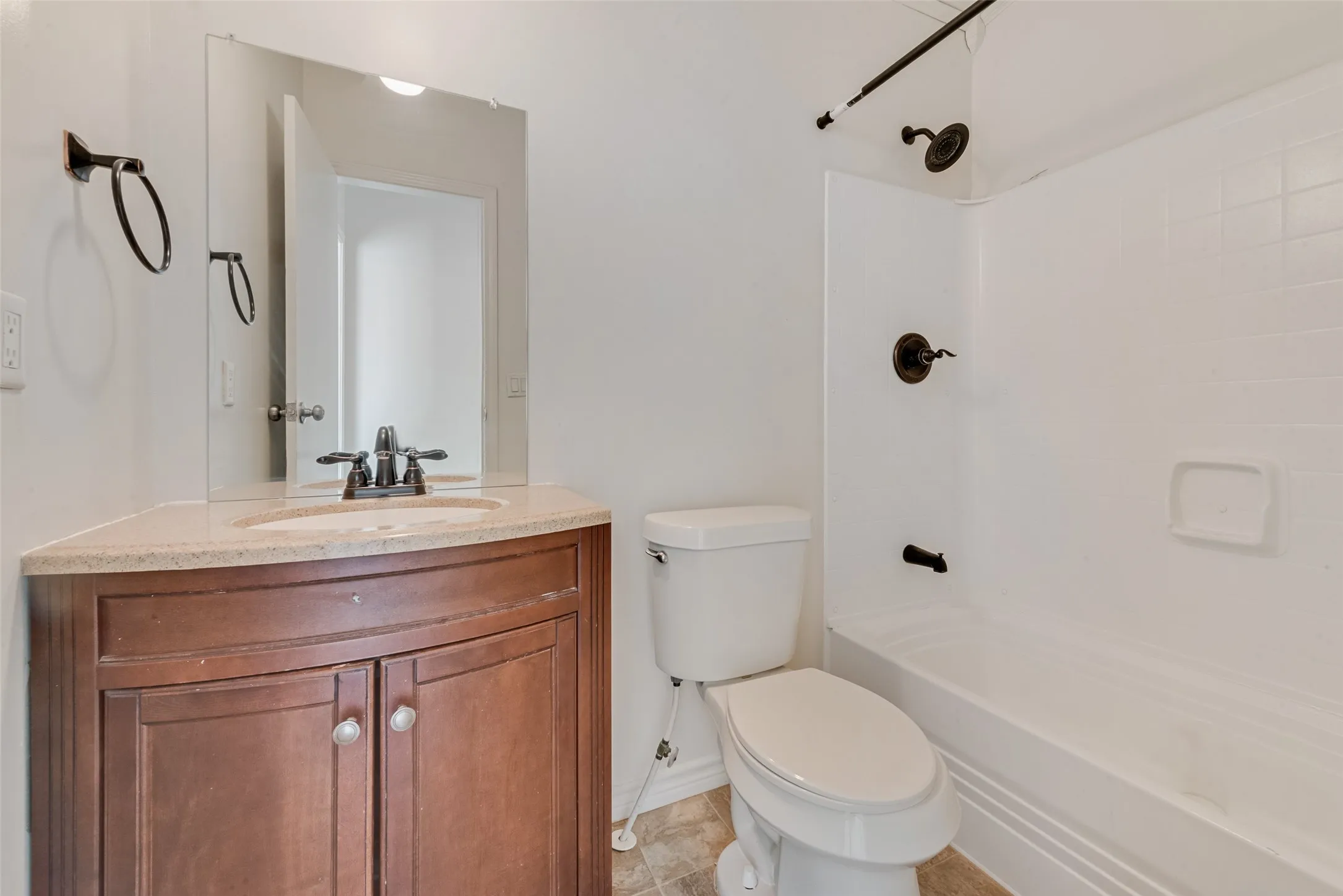 Bathroom with vanity, tub / shower combination, and light tile patterned floors