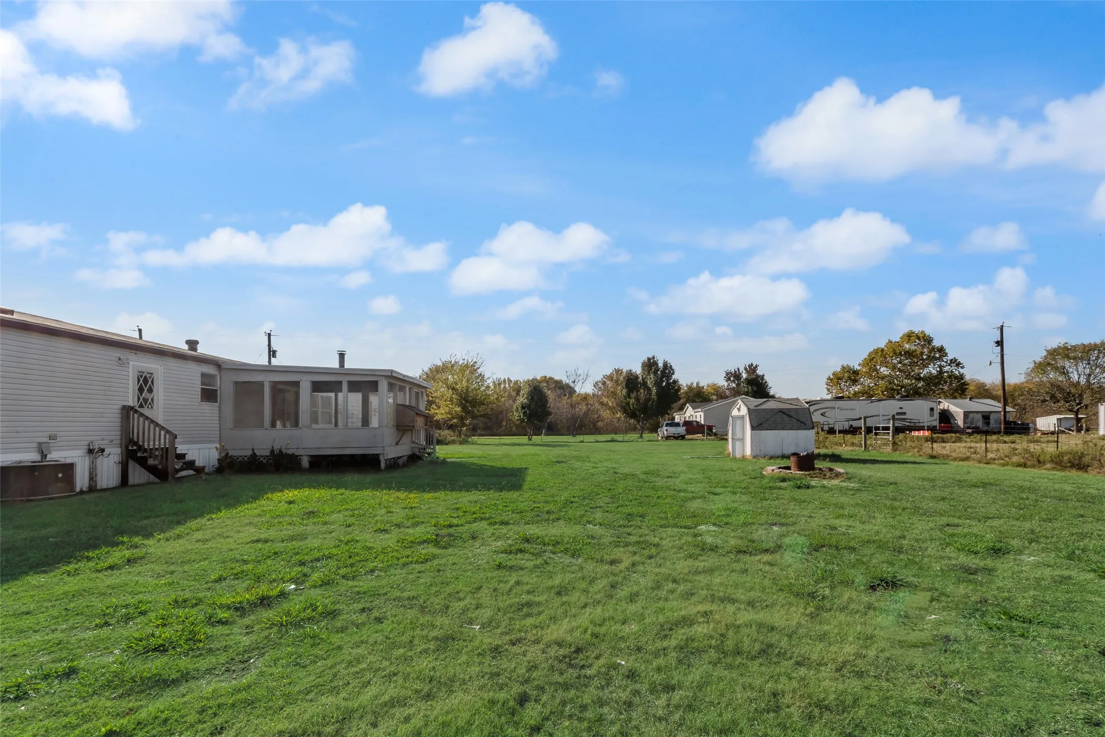 View of green lawn featuring a sunroom