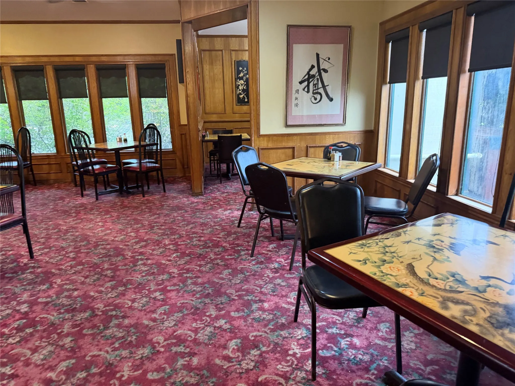 Dining area with wood walls, wainscoting, healthy amount of natural light, and dark colored carpet