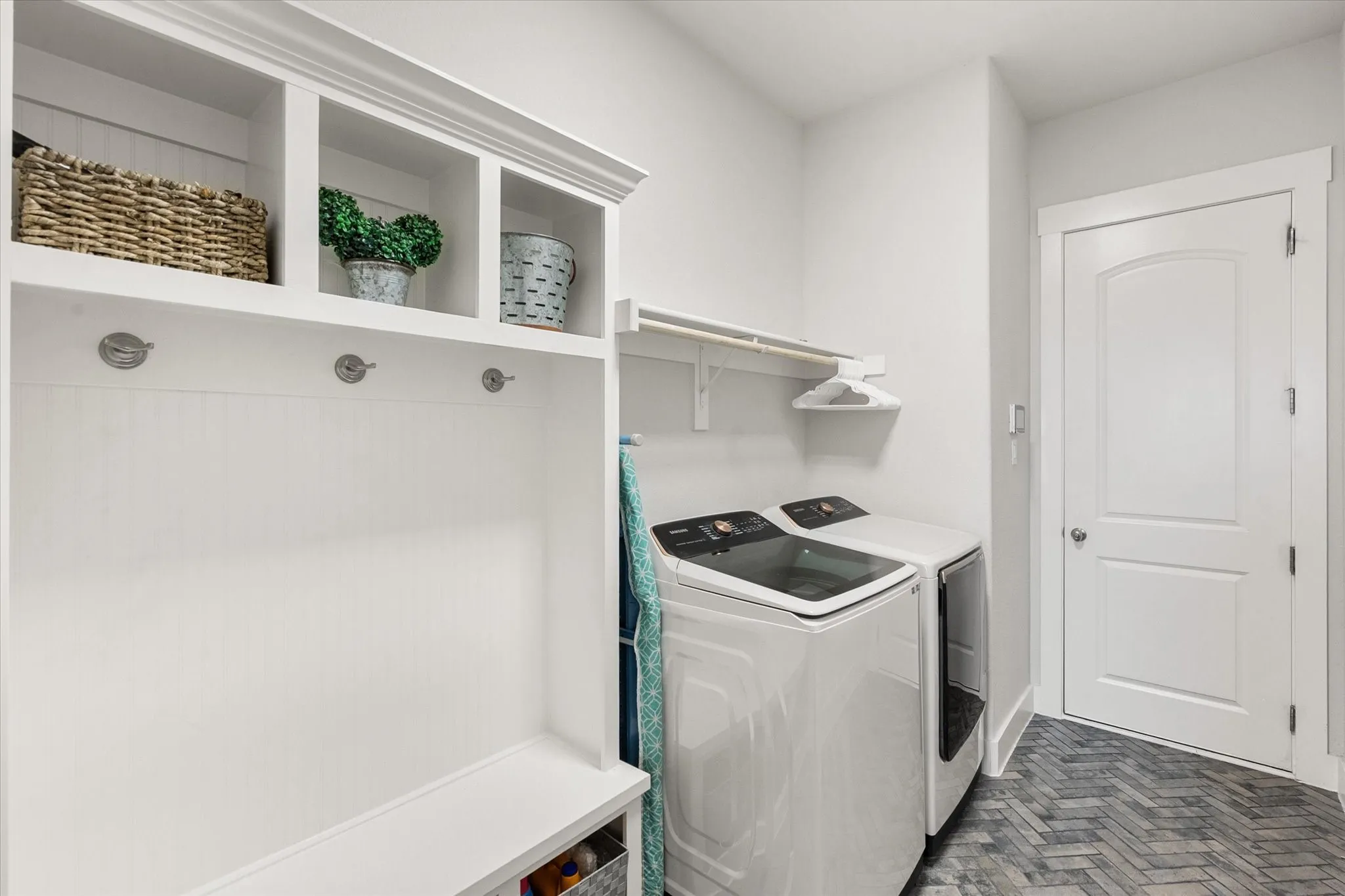 Laundry room featuring brick flooring and washer and clothes dryer