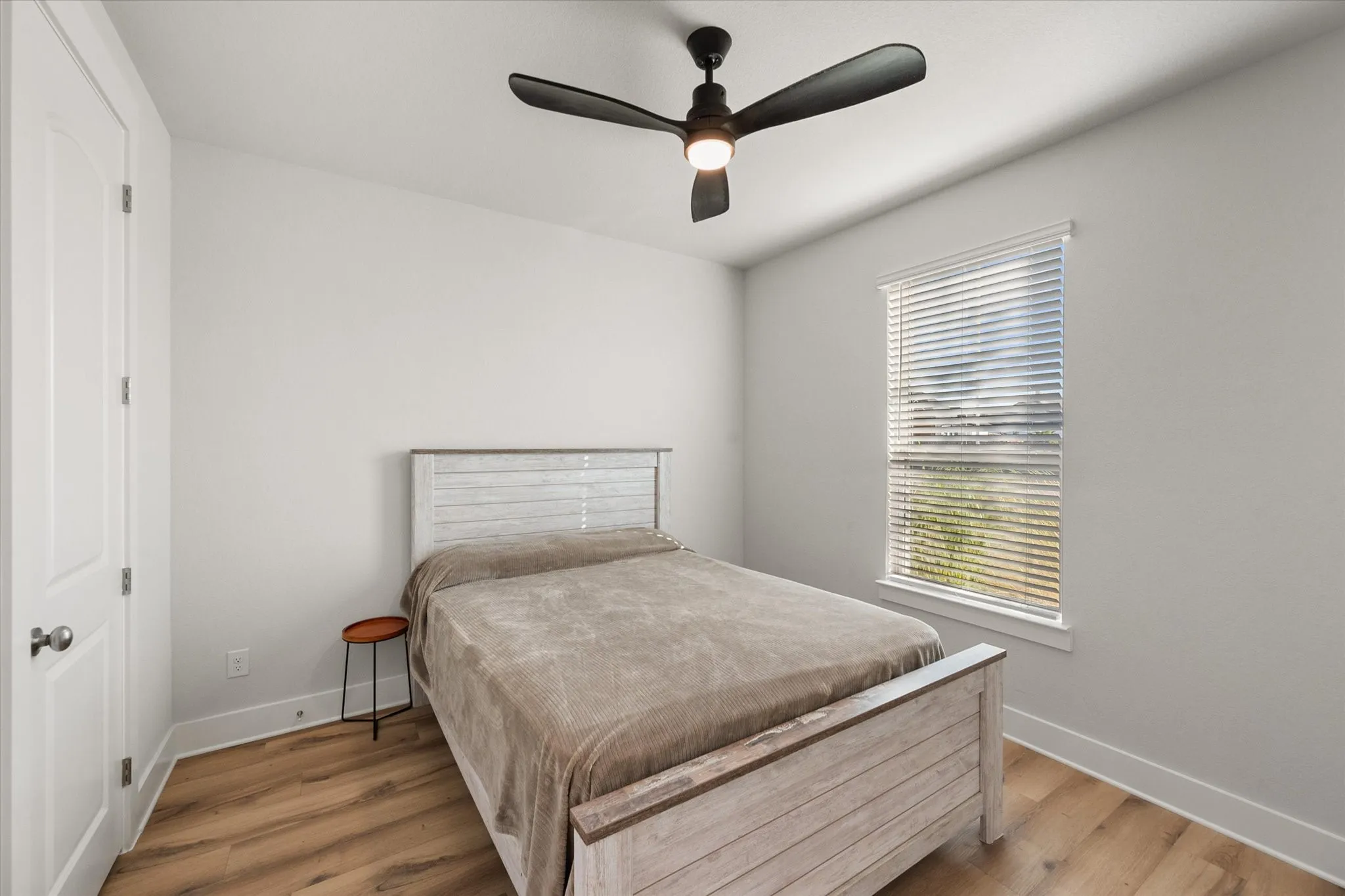 Bedroom with light wood finished floors and a ceiling fan